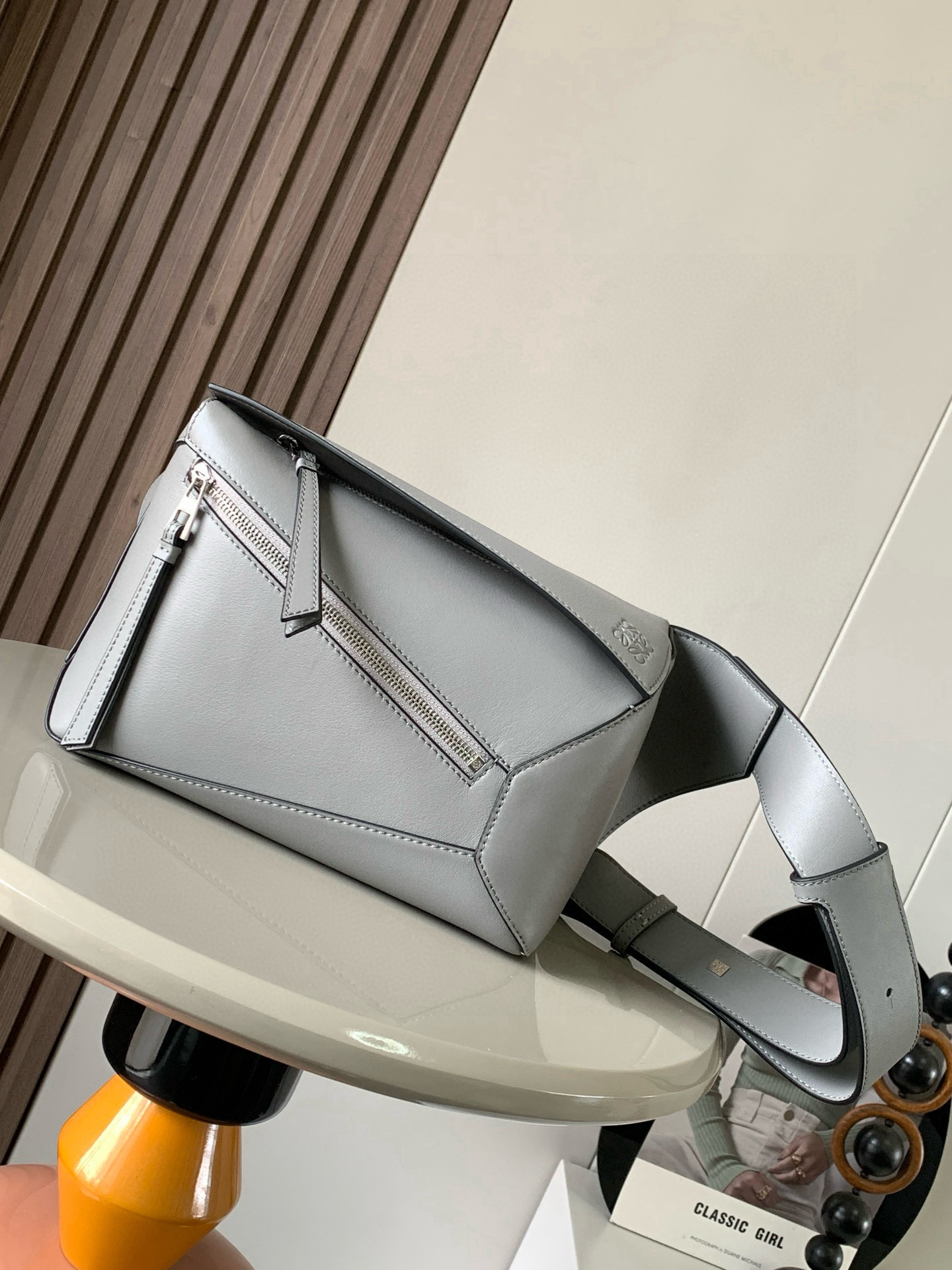 NO:532628,The new small classic cowhide leather Puzzle waist bag rectangular shape and precise cutting technology create Puzzle's unique geometric lines. This small waist bag is made of classic cowhide leather. It is soft and light. It has a low-key and recognizable shape. It can be matched with both business and casual. Later, I found a puzzle waist bag. Compared with classic, Puzzle is relatively niche. This waist bag removes the handle of the classic puzzle. The rear zipper bag at the back of the classic puzzle is moved to the front belt and becomes an unremovable latch buckle wide belt retains the basic bag shape of the classic puzzle casual literary style. In addition, the fork adds a cool mechanical feel and is also classic and versatile. Not only is the capacity considerable, but the upper body proportions are better. Shoulder or crossbody, adjustable shoulder straps, and metal buckle closure.  Size 24CM~16CM~10.5CM Model number 9114 Color asphalt gray, Loewe, cowhide19860909新款小号经典牛皮革 Puzzle 腰包长方体形状和精确的切割技术创造了Puzzle 独特的几何线条这款小号腰包采用经典牛皮革制成皮质柔软轻便,造型低调有辨识度不管是商务还是休闲都可以搭配后来叉发现一款 puzzle腰包,相对经典,puzzle 来说比较小众此款腰包去掉了经典puzzle的手柄把经典puzzle 后面的后置拉链袋移到了前面腰带也变成不可拆卸插销扣宽腰带保留经典puzzle随性文艺的基本包型外,叉增加了一份酷酷的机械感同样经典百搭. 不仅容量可观而且上身比例更好.肩背或斜挎 ,可调节肩带,配有金属搭扣开合 尺寸24CM～16CM～10.5CM 款号9114 颜色沥青灰,罗意威,loewe,cowhide,Bag