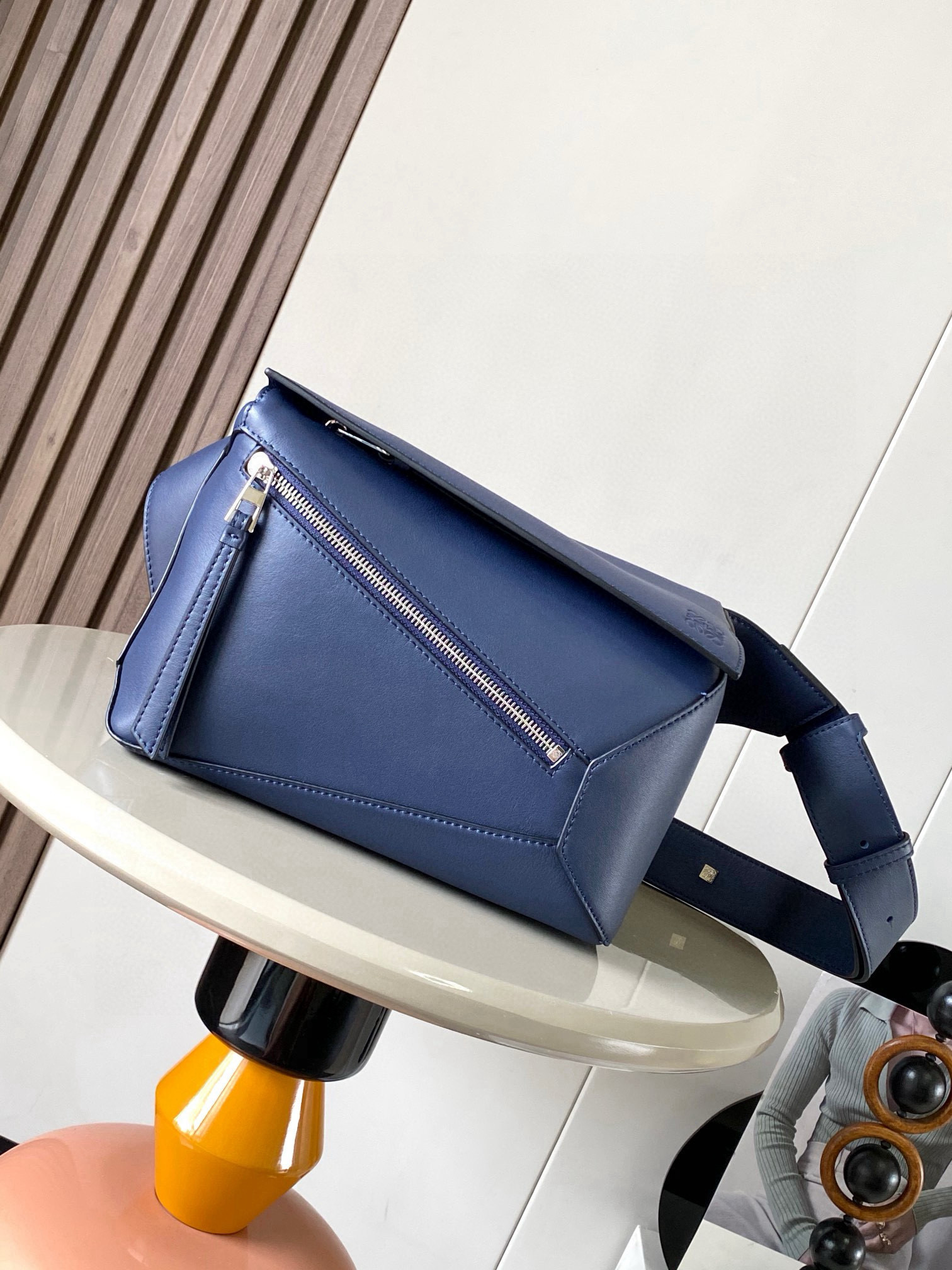 NO:532651,The new small classic cowhide leather Puzzle waist bag rectangular shape and precise cutting technology create Puzzle's unique geometric lines. This small waist bag is made of classic cowhide leather. It is soft and light. It has a low-key and recognizable shape. It can be matched with both business and casual. Later, I found a puzzle waist bag. Compared with classic, Puzzle is relatively niche. This waist bag removes the handle of the classic puzzle. The rear zipper bag at the back of the classic puzzle. The belt belt moves the back of the classic puzzle. It also becomes an unremovable latch buckle. The wide belt retains the basic bag shape of the classic puzzle casual literary style. In addition, the fork adds a cool mechanical feeling. It is also classic and versatile. Not only has considerable capacity but also has a better upper body proportion. It has an adjustable shoulder strap, equipped with a metal buckle closure. Size 24CM~16CM~10.5CM  Model number 9114 color navy, Loewe, cowhide19860909新款小号经典牛皮革 Puzzle 腰包长方体形状和精确的切割技术创造了Puzzle 独特的几何线条这款小号腰包采用经典牛皮革制成皮质柔软轻便,造型低调有辨识度不管是商务还是休闲都可以搭配后来叉发现一款 puzzle腰包,相对经典,puzzle 来说比较小众此款腰包去掉了经典puzzle的手柄把经典puzzle 后面的后置拉链袋移到了前面腰带也变成不可拆卸插销扣宽腰带保留经典puzzle随性文艺的基本包型外,叉增加了一份酷酷的机械感同样经典百搭 不仅容量可观而且上身比例更好.肩背或斜挎 ,可调节肩带,配有金属搭扣开合 尺寸24CM～16CM～10.5CM 款号9114 颜色海军蓝,罗意威,loewe,cowhide,Bag