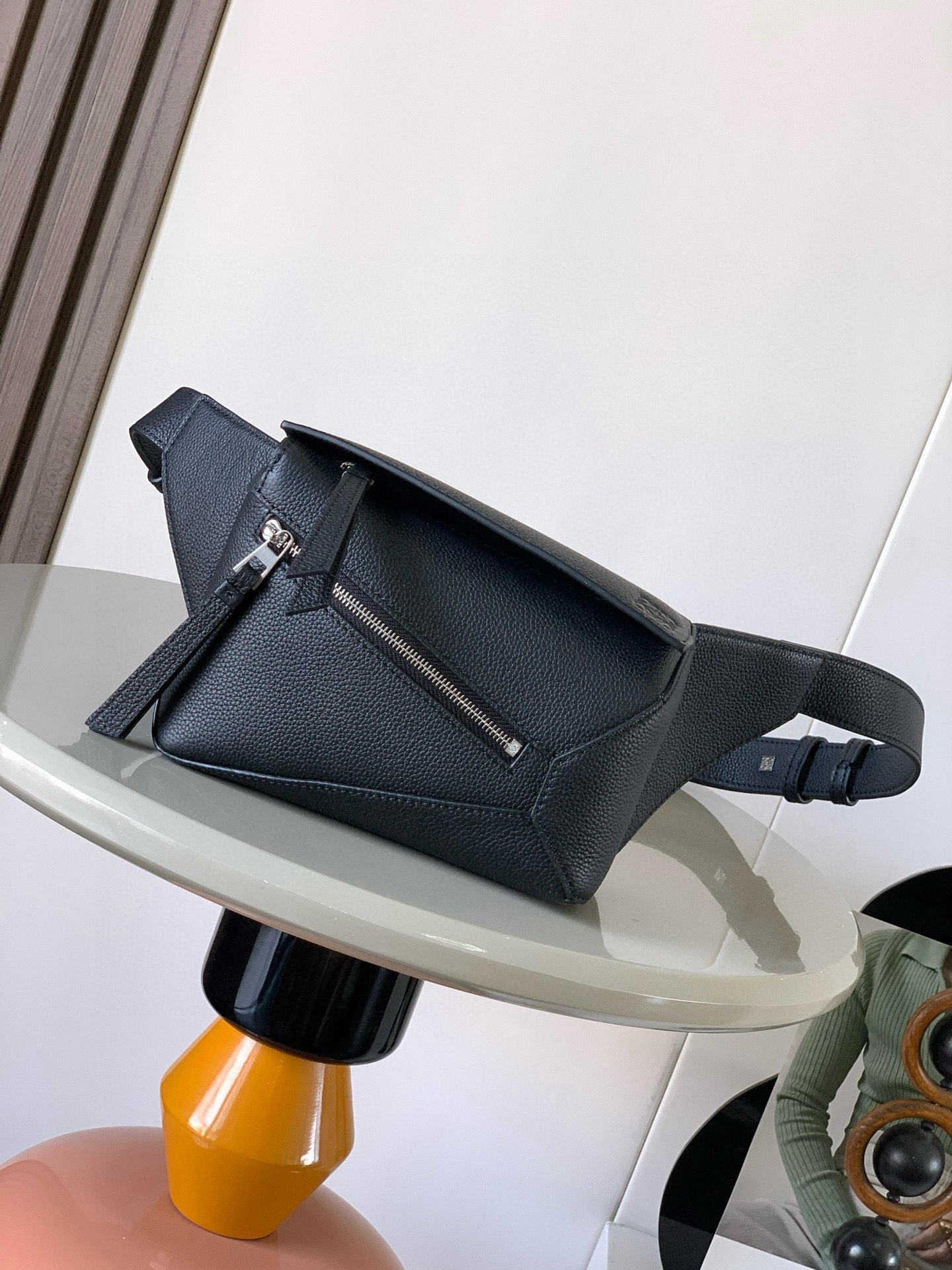 NO:532769,The new mini classic cowhide leather Puzzle waist bag rectangular shape and precise cutting technology create Puzzle's unique geometric lines. This small mini waist bag is made of classic cowhide leather. It is soft and light. It has a low-key and recognizable shape. It can be matched with both business and casual. Later, I found a puzzle waist bag. Compared with classic, Puzzle is relatively niche. This waist bag removes the handle of the classic puzzle. The rear zipper bag at the back of the classic puzzle is moved to the front belt and becomes an unremovable latch buckle. The wide belt retains the basic bag shape of the classic puzzle casual literature. In addition, the fork adds a cool mechanical feeling. It is also classic and versatile. Not only has a considerable capacity but also has a better upper body proportion. Shoulder or crossbody, adjustable shoulder straps, equipped with metal buckle closure.  Size 18CM~12CM~7.5CM Model number 9115 Color black lyre, Luo Yiwei, loewe, cowhide19860909新款迷你号经典牛皮革 Puzzle 腰包长方体形状和精确的切割技术创造了Puzzle 独特的几何线条这款小迷你号腰包采用经典牛皮革制成皮质柔软轻便,造型低调有辨识度不管是商务还是休闲都可以搭配后来叉发现一款 puzzle腰包,相对经典,puzzle 来说比较小众此款腰包去掉了经典puzzle的手柄把经典puzzle 后面的后置拉链袋移到了前面腰带也变成不可拆卸插销扣宽腰带保留经典puzzle随性文艺的基本包型外,叉增加了一份酷酷的机械感同样经典百搭不仅容量可观而且上身比例更好.肩背或斜挎 ,可调节肩带,配有金属搭扣开合 尺寸18CM～12CM～7.5CM 款号9115 颜色黑色荔,罗意威,loewe,cowhide,Bag