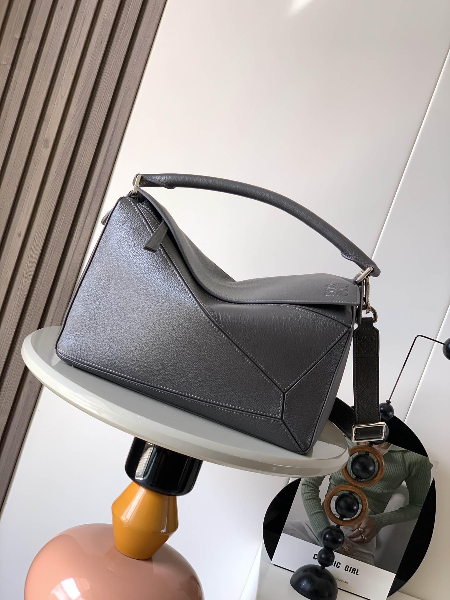 NO:574806,The new Puzzle size handbag Puzzle handbag is the creative director of Jonathan.  The first handbag launched by Jonathan Anderson, the cuboid shape and precise cutting techniques create the unique geometric lines of the Puzzle. This version is made from glossy cow leather with overlapping edges. * Can be worn on the shoulder, cross-body or handheld.  Anagram embossing meets the needs of different occasions. Unisex. Size 33cm～14.7cm～21.5cm. Style No. 9095. Color: gray coffee, Loewe, loewe, cowhide19860909新款Puzzle尺寸手袋Puzzle 手袋是创意总监乔纳森．安德森（ Jonathan Anderson）推出的首款手提包长方体形状和精确的切割技术创造了 Puzzle 独特的几何线条此版本采用亮面牛皮革制成饰有重叠边缘＊可肩背、斜挎或手提＊可拆卸可调节肩带＊外部后方拉链袋和两个内部插袋＊拉链开合牛皮革拉链头＊可以使用肩带和个性化挂饰进行定制＊绒面革衬里＊ Anagram 压纹 满足不同场合需求男女通用 尺寸33cm～14.7cm～21.5cm 款号9095 颜色灰咖,罗意威,loewe,cowhide,Bag