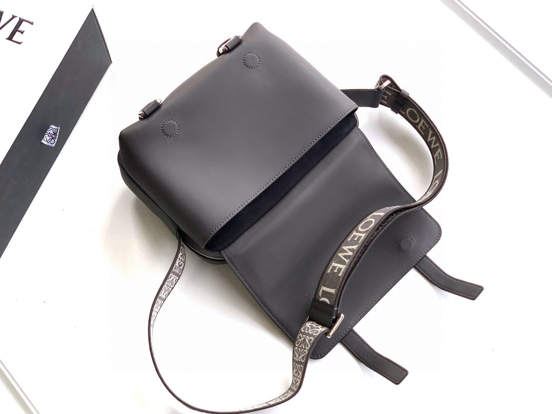 p750。🔥L0e💎we新款XS邮差包👜military messenger经典信使包 ✉️此款一改过去经典邮差包做法，设计了拉链主隔层，前部搭配搭扣打开方式放隐私物品❤️安全之余更加人性化。整體感覺更無懈可击.内置两卡槽，香烟，手机，充电宝，钱夹，收纳理想指数5颗星🌟🌟🌟🌟🌟采用进口荔枝纹小牛皮搭配背部柔软细纹皮小牛皮，🉑️调节的棉质织带肩带,使用舒适感倍增！
尺寸：23CM～18CM～9CM
款号：9011
颜色：灰咖