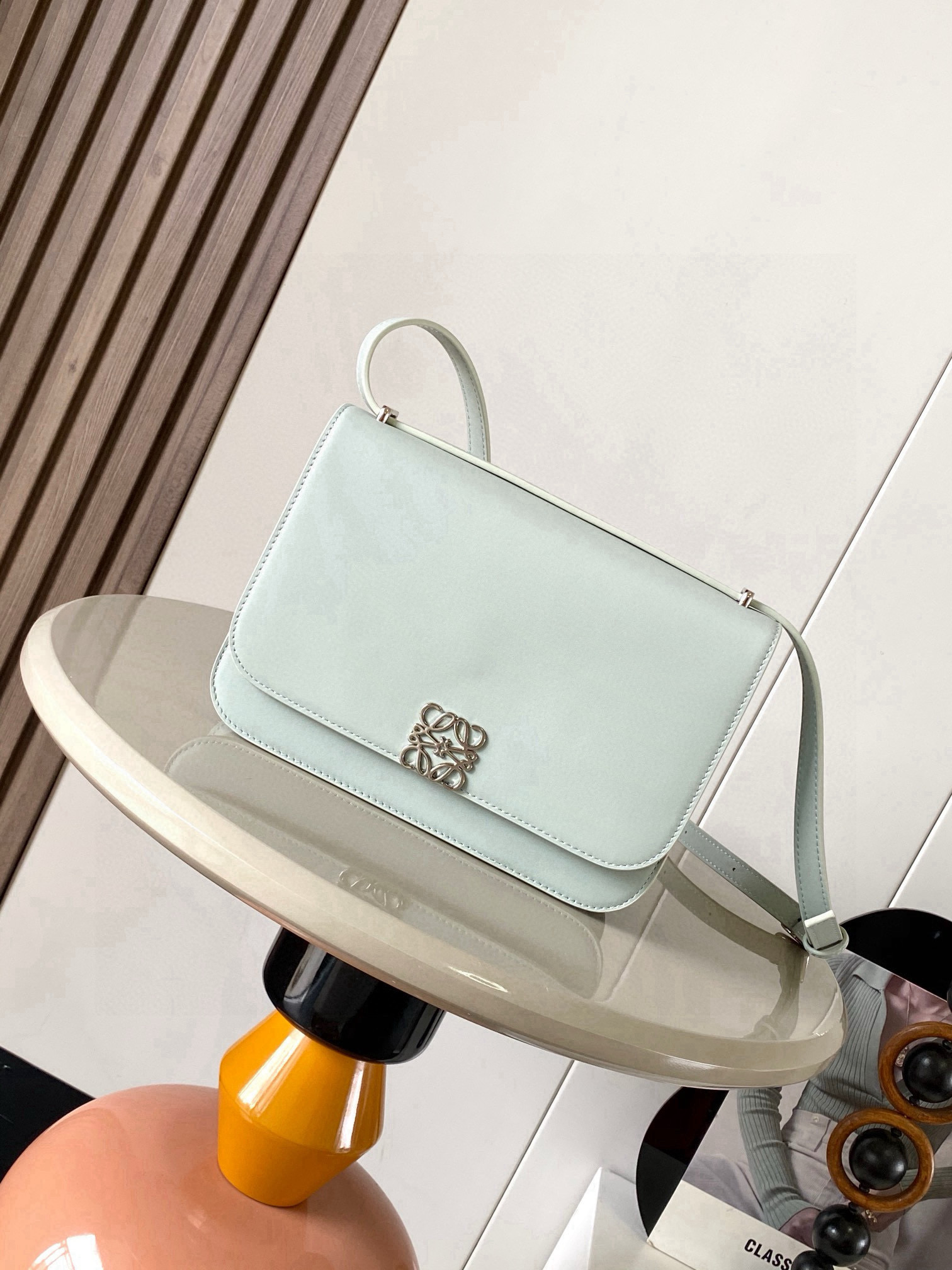 NO:556410,Goya Silk Calf Leather Handbag The Goya is a compact bag that is very well organized for its size. Simple Anagram  The closure and vibrant colors contrast with its sharp graphic simplicity It's handcrafted from fine silk cowhide and lined in soft nappa sheepskin It's the ultimate expression of craftsmanship  Size 22.5cm～7.5cm～15cm Style number 9067 Color light gray, Loewe, loewe, loewe, cowhide, sheepskin19860909Goya丝绸牛皮革手袋Goya 是一款结构紧凑的包袋,对于其尺寸来说,手袋组织得非常到位简洁的 Anagram 封口和鲜艳的色彩与其锐利的图形简约感形成鲜明的对比它采用精美的丝绸牛皮革手工制作衬里为柔软纳帕羊皮革它是精湛工艺的终极体现＊肩背＊可调节肩带＊磁扣＊四个内部口袋,包括一个拉链口袋和一个按扣口袋＊一个外部口袋＊纳帕羊皮革衬里＊肩带上饰有金属压纹 LOEWE 标志 里料羊皮革／牛皮革 尺寸22.5cm～7.5cm～15cm 款号9067 颜色浅轻灵灰,罗意威,loewe,loewe,cowhide,sheepskin,Bag