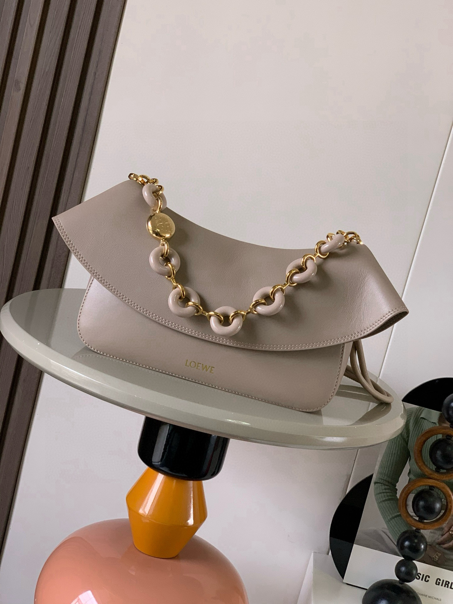 NO:582127,Medium Smooth Cow Leather Ola Handbag Ola is a soft, lightweight, flexible and versatile summer handbag with a curved body, a smooth-line flap and a striking donut chain. This medium version is made of smooth cow leather * Detachable cow leather tubular shoulder strap Detachable donut chain * Flap closure * One inner pocket L0EWE Hot stamping, engraved Anagram logo Size 26CM ~ 18CM ~ 13CM Style No. 9150  Color sandy,loewe,loewe,cowhide19860909中号光滑牛皮革 Ola 手袋Ola 是柔软轻便且灵活百搭的夏日手袋采用弧形主体、线条流畅的翻盖和醒目甜甜圈链条此中号版本采用光滑牛皮革制成*可拆卸牛皮革管状肩带可拆卸甜甜圈链条*翻盖开合*一个内袋 L0EWE 烫金,镌刻 Anagram 标志 尺寸26CM～18CM～13CM 款号9150 颜色沙色,罗意威,loewe,cowhide,Bag