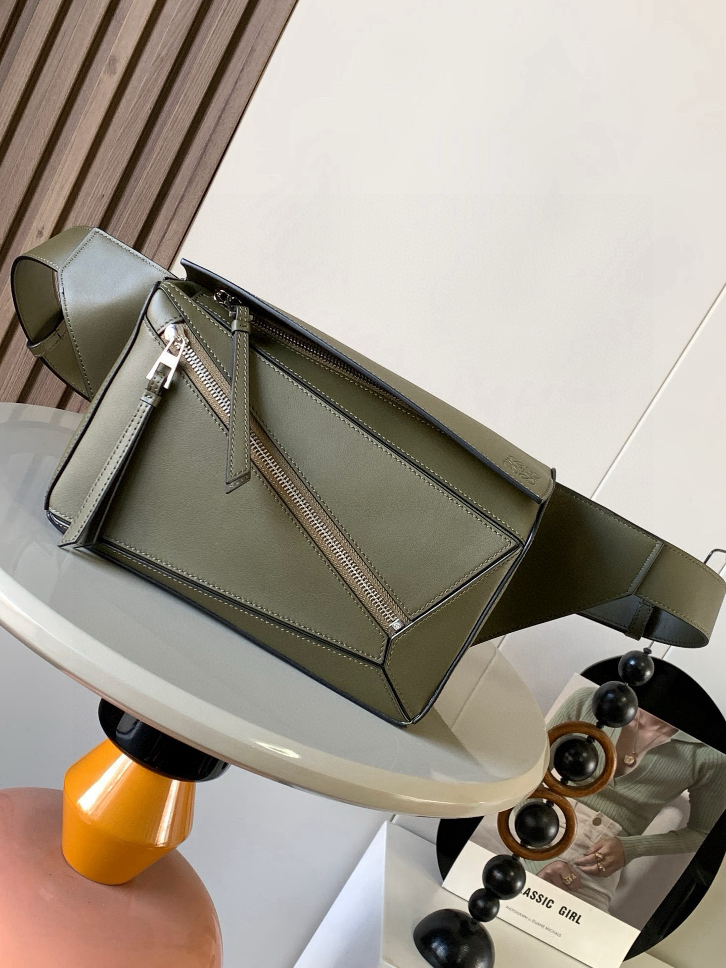 NO:574884,Small classic cow leather Puzzle waist bag The rectangular shape and precise cutting technology create Puzzle's unique geometric lines. This small waist bag is made of classic cow leather. The leather is soft and lightweight, and the shape is low-key and recognizable. It can be matched with the back for both business and leisure. I found a puzzle waist bag, which is relatively classic and relatively niche for puzzle. This waist bag removes the handle of the classic puzzle and puts the classic puzzle  The rear zipper bag has been moved to the front belt and has become a non-detachable latch buckle wide belt. In addition to retaining the classic puzzle casual and artistic basic bag shape, the fork adds a cool mechanical feel and is also classic and versatile. Not only is the capacity considerable, but the upper body proportion is better. Shoulder or crossbody, adjustable shoulder strap, equipped with metal buckle closure. Size 24CM～16CM～10.5CM. Style No. 8014. Color green, Loewe, loewe, cowhide.19860909小号经典牛皮革 Puzzle 腰包长方体形状和精确的切割技术创造了Puzzle 独特的几何线条这款小号腰包采用经典牛皮革制成皮质柔软轻便,造型低调有辨识度不管是商务还是休闲都可以搭配后来叉发现一款 puzzle腰包,相对经典,puzzle 来说比较小众此款腰包去掉了经典puzzle的手柄把经典puzzle 后面的后置拉链袋移到了前面腰带也变成不可拆卸插销扣宽腰带保留经典puzzle随性文艺的基本包型外,叉增加了一份酷酷的机械感同样经典百搭. 不仅容量可观而且上身比例更好.肩背或斜挎 ,可调节肩带,配有金属搭扣开合 尺寸24CM～16CM～10.5CM 款号8014 颜色绿色,罗意威,loewe,cowhide,Bag