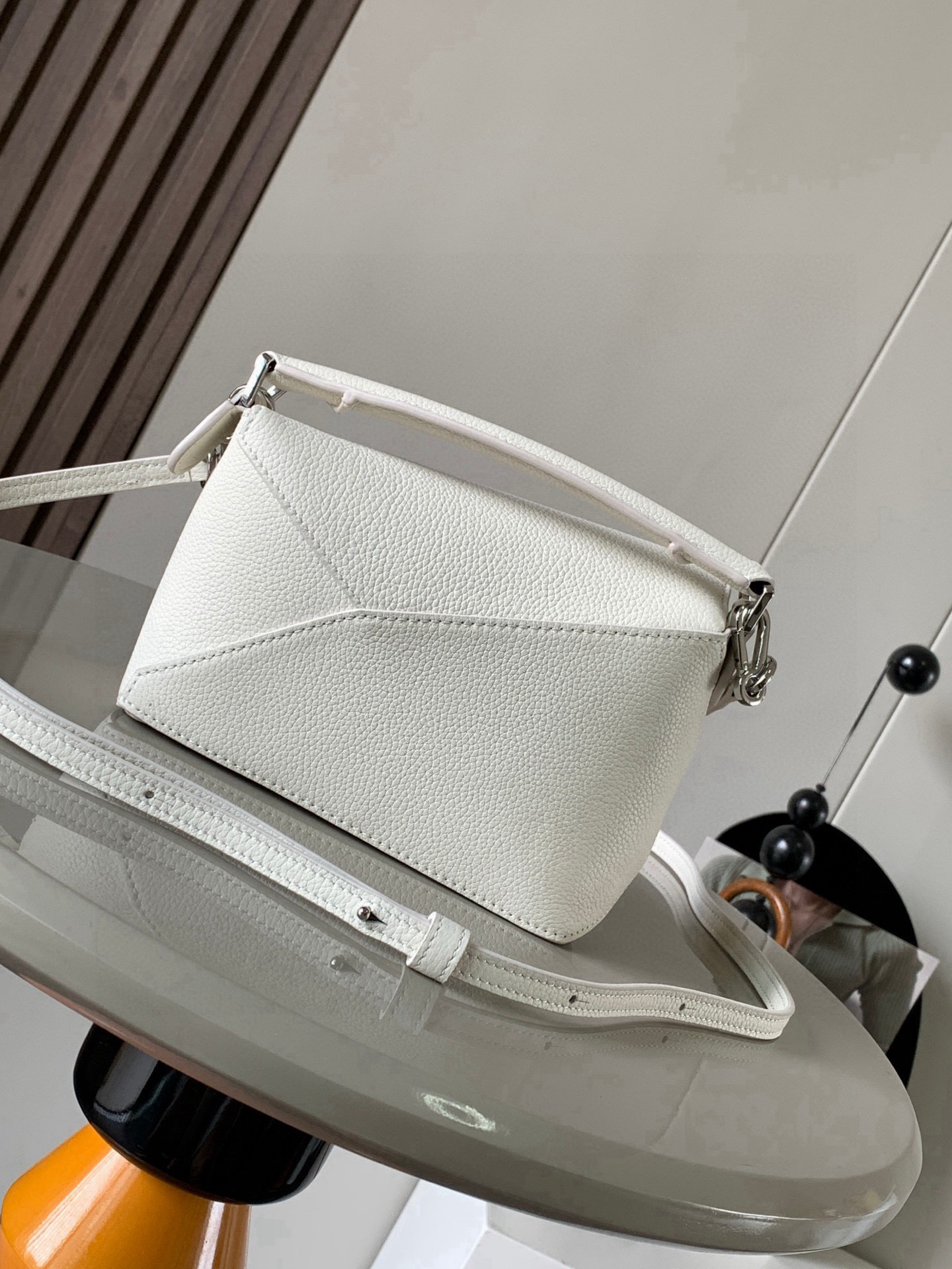 p650。🔥爆款🔥新版本几何包迷你18CM🌹原厂进口纳帕小牛皮👜Puzzle手袋是创意总监乔纳森．安德森为 L0💋EWE 推出的首款手提包🔥长方体形状和精确的切割技术创造了 Puzzle 独特的几何线条。这个迷你版本采用经典牛皮革制成👍迷你 Puzzle 可以容纳例如一只小号垂直钱包、大多数尺寸的手机（最大6.1英寸）和太阳镜盒💄斜挎、肩背、手拿或顶部提手携带.可拆卸肩带🤍包包自身重量几乎🉑忽略，炒鸡实用，出门装手机小钱包口红粉饼,毫无累赘感，轻松愉快人生从此开启😇😇(你们最关心的xs，plus都ok哈）😍
尺寸：18～12.5～8CM
款号：8003
颜色：白色