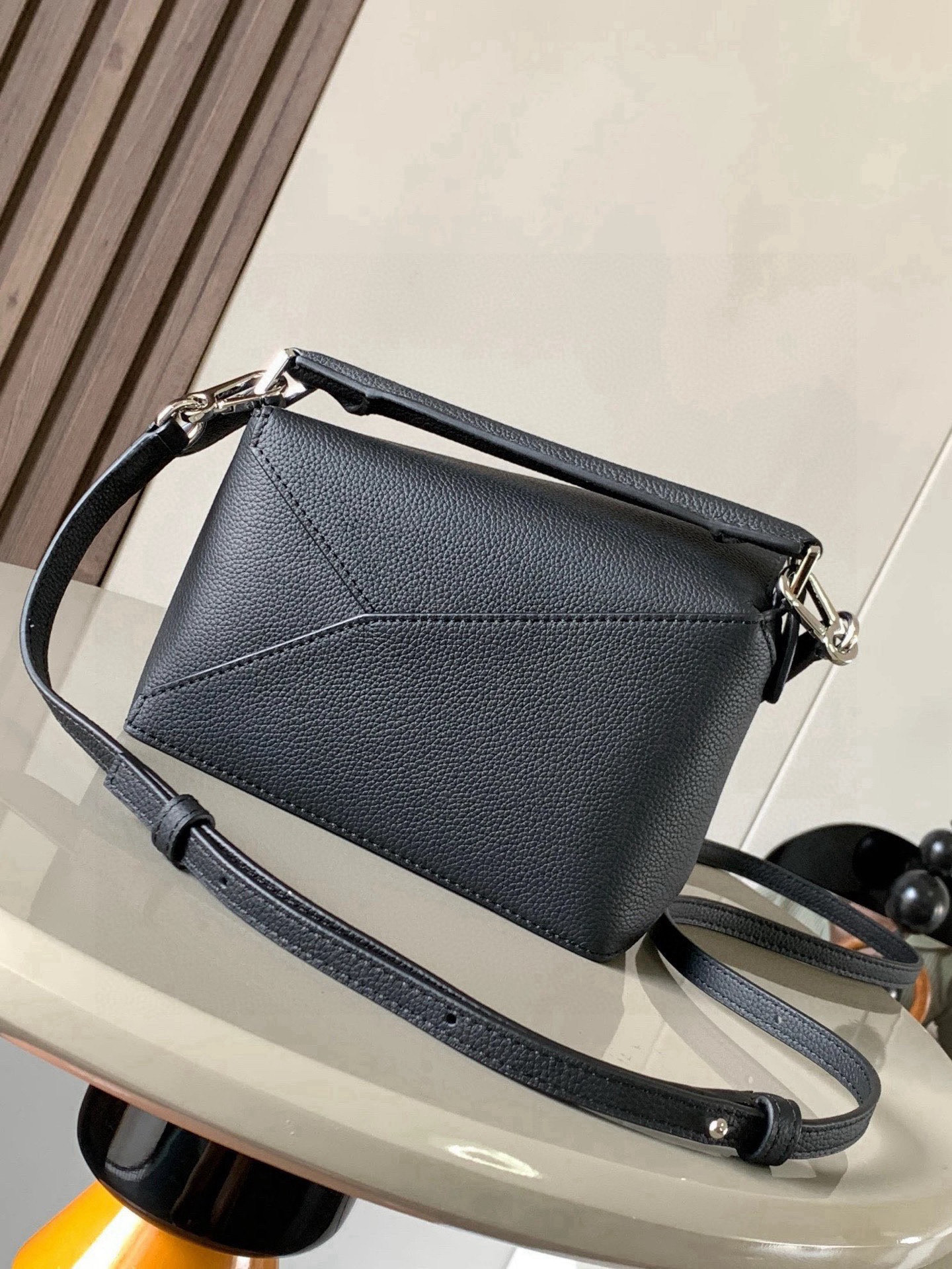 p650。🔥爆款🔥新版本几何包迷你18CM🌹原厂进口纳帕小牛皮👜Puzzle手袋是创意总监乔纳森．安德森为 L0💋EWE 推出的首款手提包🔥长方体形状和精确的切割技术创造了 Puzzle 独特的几何线条。这个迷你版本采用经典牛皮革制成👍迷你 Puzzle 可以容纳例如一只小号垂直钱包、大多数尺寸的手机（最大6.1英寸）和太阳镜盒💄斜挎、肩背、手拿或顶部提手携带.可拆卸肩带🖤包包自身重量几乎🉑忽略，炒鸡实用，出门装手机小钱包口红粉饼,毫无累赘感，轻松愉快人生从此开启😇😇(你们最关心的xs，plus都ok哈）😍
尺寸：18～12.5～8CM
款号：8003
颜色：黑色