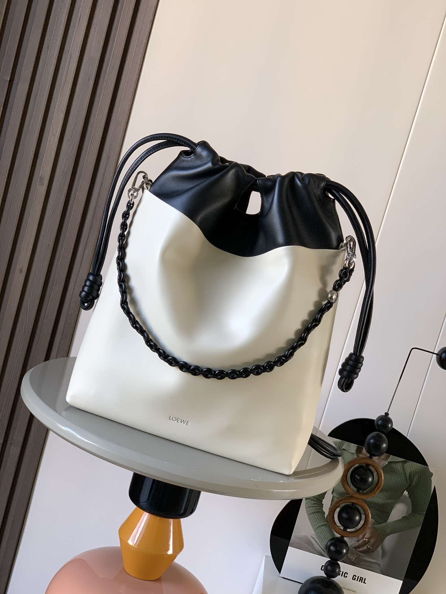 NO:582170,The new new soft two-tone nappa lambskin Flamenco Purse tote bag is a soft and practical bag with a straight design, time-honored drawstrings, knots and a tonal donut chain strap with a contrasting top. This version is made of soft nappa lambskin and can be worn on the shoulder, crossbody or hand-held.  Style No. 9101 Color sea salt white/black, Loewe, loewe, totes, sheepskin, chamois leather19860909新款新柔软双色纳帕小羊皮 Flamenco Purse 托特包是柔软实用的包款采用直式设计、历史悠久的抽绳、绳结和与对比色顶部搭配的同色系甜甜圈链带此版本以柔软纳帕小羊皮制成可肩背、斜背或手提,顶部手提把,皮革肩带可调整拆卸可拆式甜甜圈链带装饰Anagram Pebble磁扣麂皮内里 尺寸38～29～9CM 款号9101 颜色海盐白/黑,罗意威,loewe,totes,sheepskin,chamois leather,Bag