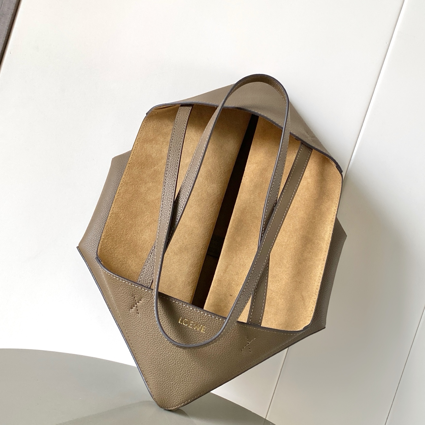 p830。🔥新款🎁中号柔软粒面牛皮革横版 Puzzle Fold 手袋⚡️Puzzle Fold 采用轻盈几何结构设计💥能够完全扁平折叠🍉是旅行良伴🥪此中号横版手袋采用柔软粒面牛皮革制成👑*可肩背或手提*绒面革衬里💕🍻
尺寸：31.5～29～12.5CM
款号：9104
颜色：灰褐色荔