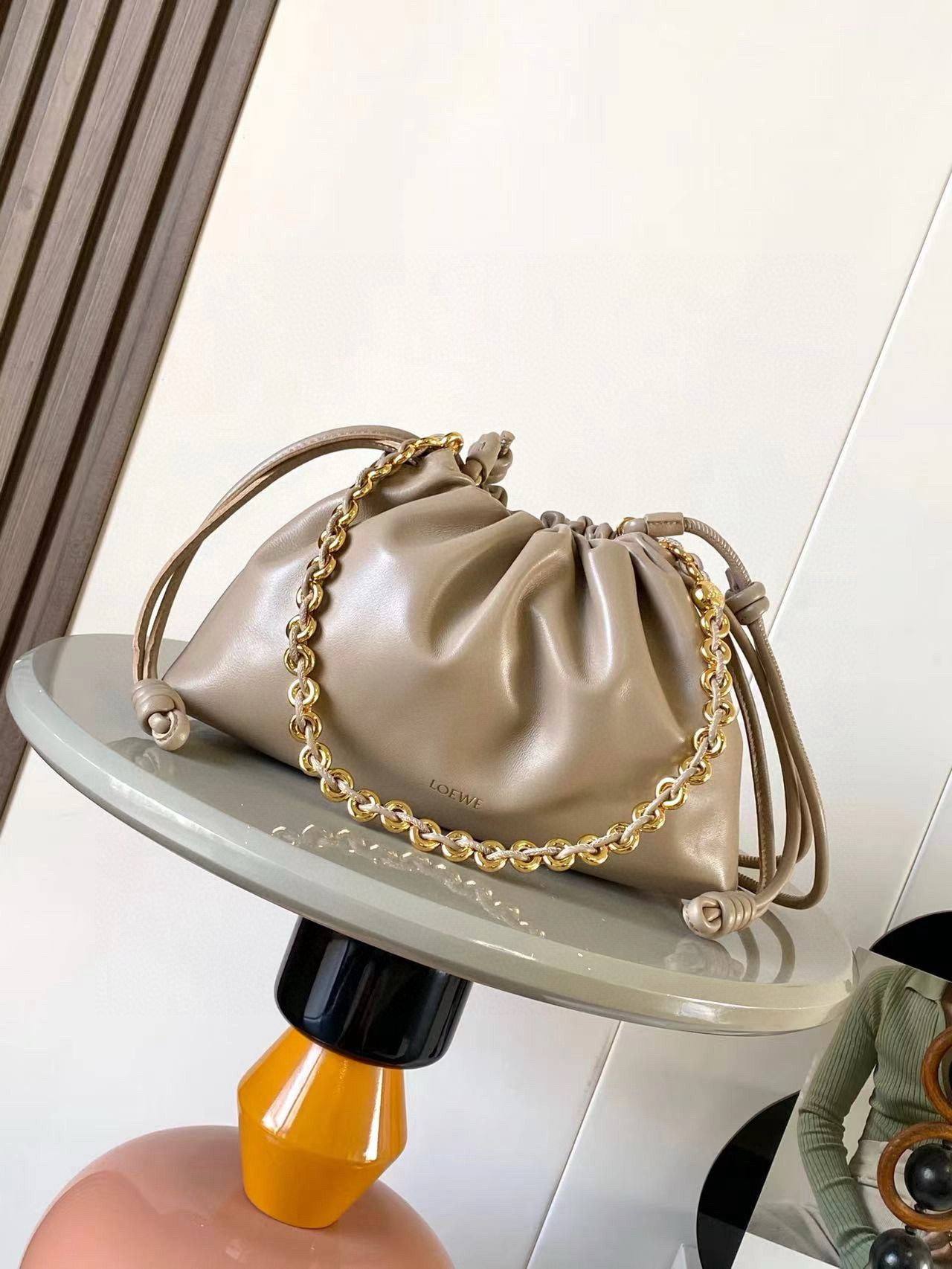 NO:583824,The new medium flamenco purse clutch in deer leather stars the same Flamenco Purse. It has a pleated design and signature knots on the side. This medium version is made of deer leather * Can be worn on the shoulder, cross-body or handbag * Detachable and adjustable leather shoulder strap * Detachable donut chain decorated with Anagram Pebble  ＊Ultra-light, super-soft and scratch-resistant, it comes with two shoulder straps and can be worn on one shoulder or cross-body. Magnetic buckle closure ＊Suede lining* LOEWE hot silver Size 30cm～10.5cm～20cm Style No. 9057 Color Gravel, Loewe, loewe, loewe, handbag19860909新款中号鹿皮革 Flamenco Purse 手拿包明星同款Flamenco Purse 采用褶皱设计,侧面搭配标志性绳结此中号版本采用鹿皮革制成＊可肩背、斜挎或手提＊可拆卸可调节皮革肩带＊可拆卸甜甜圈链条饰有Anagram Pebble ＊超轻超软耐划痕,随意搭配自带两个肩带,单肩斜背都可以.磁扣开合＊绒面革衬里* LOEWE 烫银 尺寸30cm～10.5cm～20cm 款号9057 颜色砂砾色,罗意威,loewe,loewe,handbag,Bag