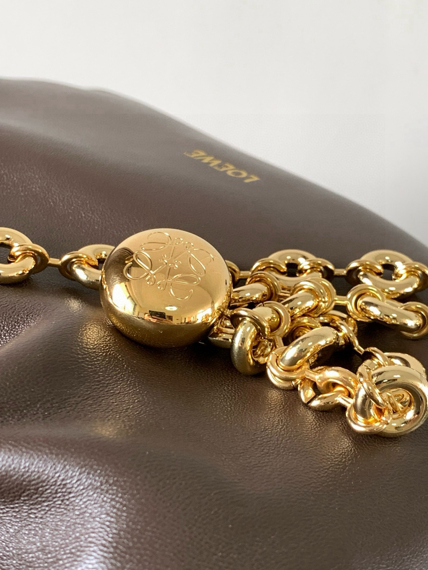 p980。🔥【明星同款】小号纳帕羊皮革Squeeze手袋💄是款精致而柔美的全新手袋💥全新发布的 Squeeze 手袋采用柔软丝滑的Mellow纳帕小羊皮制作而成❤️无衬里结构有效减轻包身自重🌺观感上也更为轻盈⭐️弯月形包口以优雅的褶边收口，营造出轻松又随性的态度👜这款包包还有一大亮点是符合人体工程学的 Squeeze 气囊手柄🌼搭配黄铜打造的精美甜甜圈链条😘可通过链环调节长短或添加延长链，实现手拎、肩背、斜挎等不同背法😻气囊手柄可自由滑动位置以提升舒适度🌻链条底部点缀一枚 Anagram Pebble 吊坠，为包包增添灵动细节⚡️
尺寸：29CM～24CM～10.5CM
款号：9042
颜色：巧克力