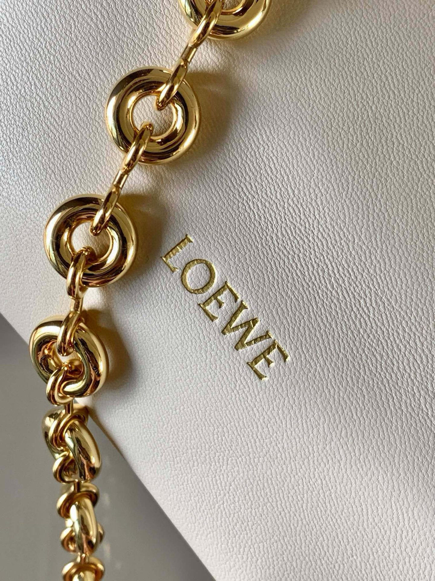 p980。🔥【明星同款】小号纳帕羊皮革Squeeze手袋💄是款精致而柔美的全新手袋💥全新发布的 Squeeze 手袋采用柔软丝滑的Mellow纳帕小羊皮制作而成❤️无衬里结构有效减轻包身自重🌺观感上也更为轻盈⭐️弯月形包口以优雅的褶边收口，营造出轻松又随性的态度👜这款包包还有一大亮点是符合人体工程学的 Squeeze 气囊手柄🌼搭配黄铜打造的精美甜甜圈链条😘可通过链环调节长短或添加延长链，实现手拎、肩背、斜挎等不同背法😻气囊手柄可自由滑动位置以提升舒适度🌻链条底部点缀一枚 Anagram Pebble 吊坠，为包包增添灵动细节⚡️
尺寸：29CM～24CM～10.5CM
款号：9042
颜色：柔白色