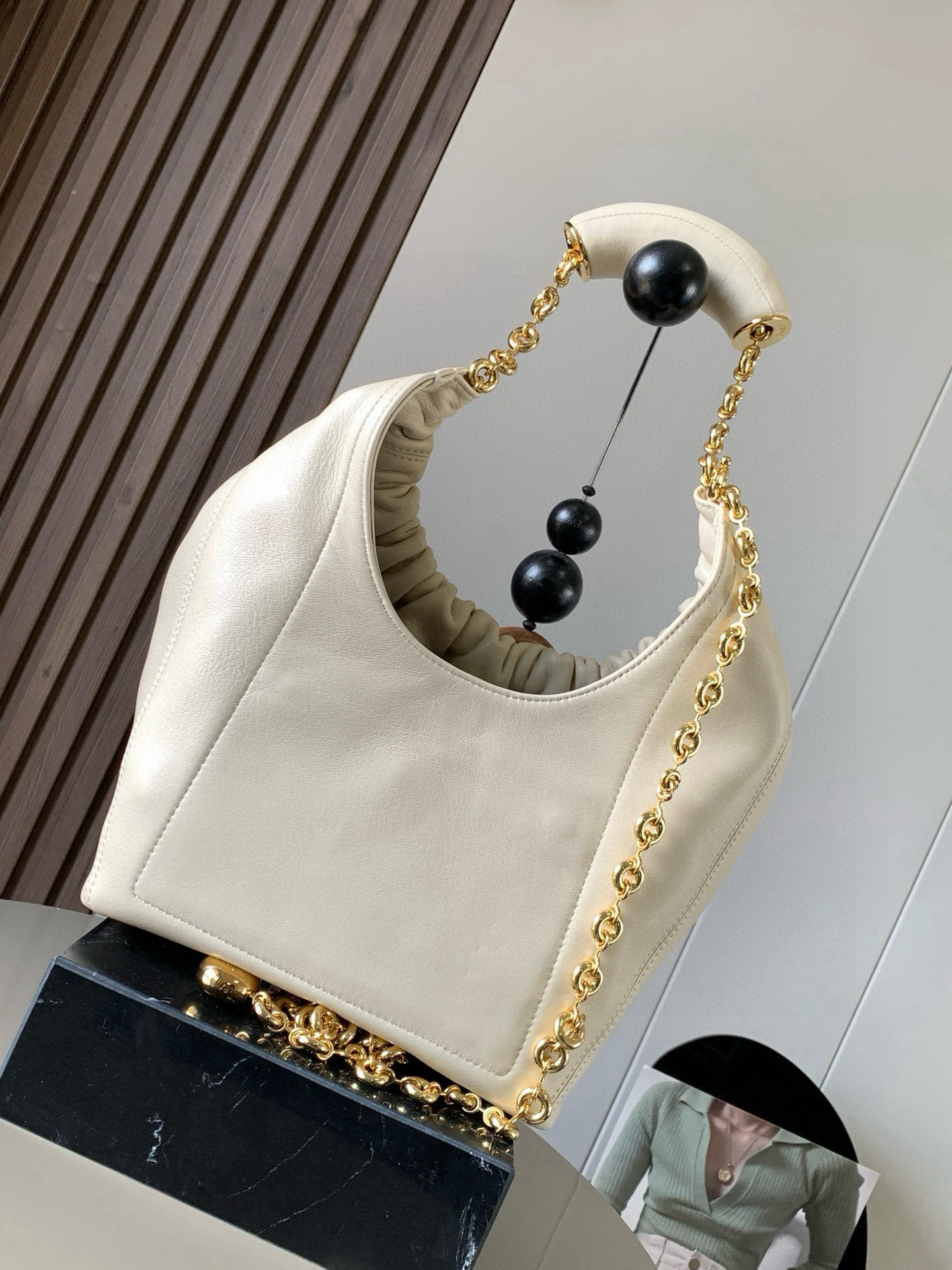 p980。🔥【明星同款】小号纳帕羊皮革Squeeze手袋💄是款精致而柔美的全新手袋💥全新发布的 Squeeze 手袋采用柔软丝滑的Mellow纳帕小羊皮制作而成❤️无衬里结构有效减轻包身自重🌺观感上也更为轻盈⭐️弯月形包口以优雅的褶边收口，营造出轻松又随性的态度👜这款包包还有一大亮点是符合人体工程学的 Squeeze 气囊手柄🌼搭配黄铜打造的精美甜甜圈链条😘可通过链环调节长短或添加延长链，实现手拎、肩背、斜挎等不同背法😻气囊手柄可自由滑动位置以提升舒适度🌻链条底部点缀一枚 Anagram Pebble 吊坠，为包包增添灵动细节⚡️
尺寸：29CM～24CM～10.5CM
款号：9042
颜色：柔白色