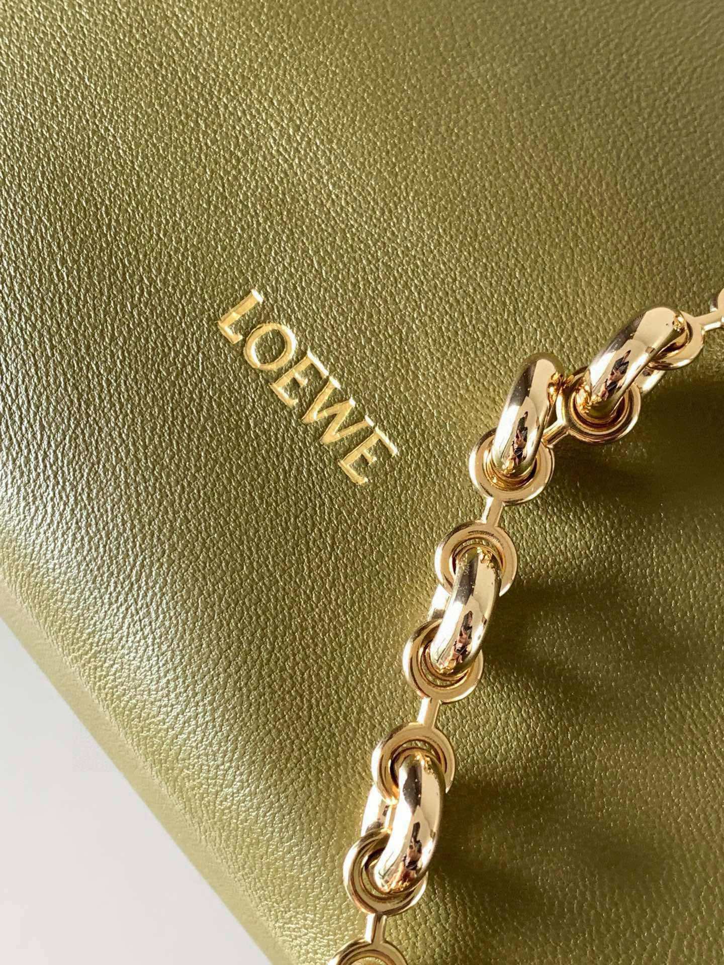 p980。🔥【明星同款】小号纳帕羊皮革Squeeze手袋💄是款精致而柔美的全新手袋💥全新发布的 Squeeze 手袋采用柔软丝滑的Mellow纳帕小羊皮制作而成❤️无衬里结构有效减轻包身自重🌺观感上也更为轻盈⭐️弯月形包口以优雅的褶边收口，营造出轻松又随性的态度👜这款包包还有一大亮点是符合人体工程学的 Squeeze 气囊手柄🌼搭配黄铜打造的精美甜甜圈链条😘可通过链环调节长短或添加延长链，实现手拎、肩背、斜挎等不同背法😻气囊手柄可自由滑动位置以提升舒适度🌻链条底部点缀一枚 Anagram Pebble 吊坠，为包包增添灵动细节⚡️
尺寸：29CM～24CM～10.5CM
款号：9042
颜色：橄榄绿