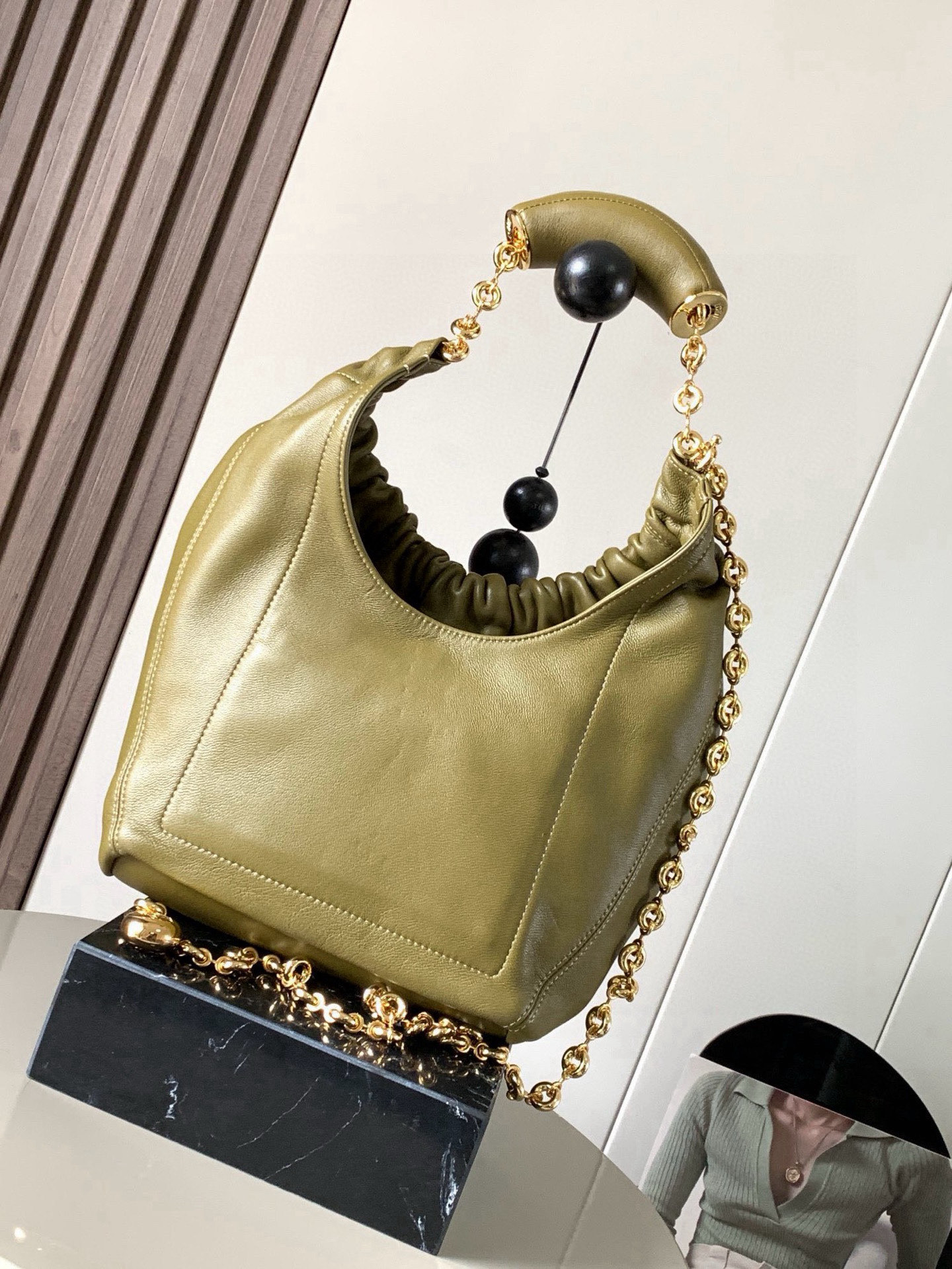 p980。🔥【明星同款】小号纳帕羊皮革Squeeze手袋💄是款精致而柔美的全新手袋💥全新发布的 Squeeze 手袋采用柔软丝滑的Mellow纳帕小羊皮制作而成❤️无衬里结构有效减轻包身自重🌺观感上也更为轻盈⭐️弯月形包口以优雅的褶边收口，营造出轻松又随性的态度👜这款包包还有一大亮点是符合人体工程学的 Squeeze 气囊手柄🌼搭配黄铜打造的精美甜甜圈链条😘可通过链环调节长短或添加延长链，实现手拎、肩背、斜挎等不同背法😻气囊手柄可自由滑动位置以提升舒适度🌻链条底部点缀一枚 Anagram Pebble 吊坠，为包包增添灵动细节⚡️
尺寸：29CM～24CM～10.5CM
款号：9042
颜色：橄榄绿