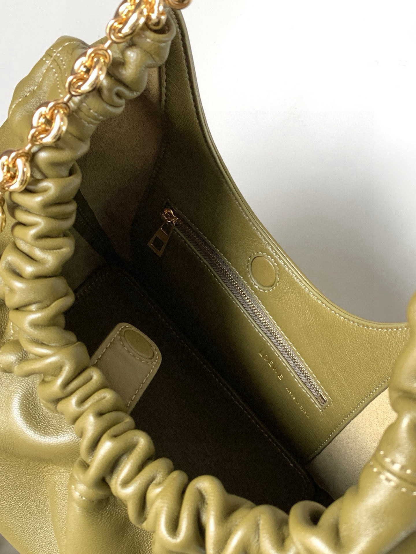 p980。🔥【明星同款】小号纳帕羊皮革Squeeze手袋💄是款精致而柔美的全新手袋💥全新发布的 Squeeze 手袋采用柔软丝滑的Mellow纳帕小羊皮制作而成❤️无衬里结构有效减轻包身自重🌺观感上也更为轻盈⭐️弯月形包口以优雅的褶边收口，营造出轻松又随性的态度👜这款包包还有一大亮点是符合人体工程学的 Squeeze 气囊手柄🌼搭配黄铜打造的精美甜甜圈链条😘可通过链环调节长短或添加延长链，实现手拎、肩背、斜挎等不同背法😻气囊手柄可自由滑动位置以提升舒适度🌻链条底部点缀一枚 Anagram Pebble 吊坠，为包包增添灵动细节⚡️
尺寸：29CM～24CM～10.5CM
款号：9042
颜色：橄榄绿