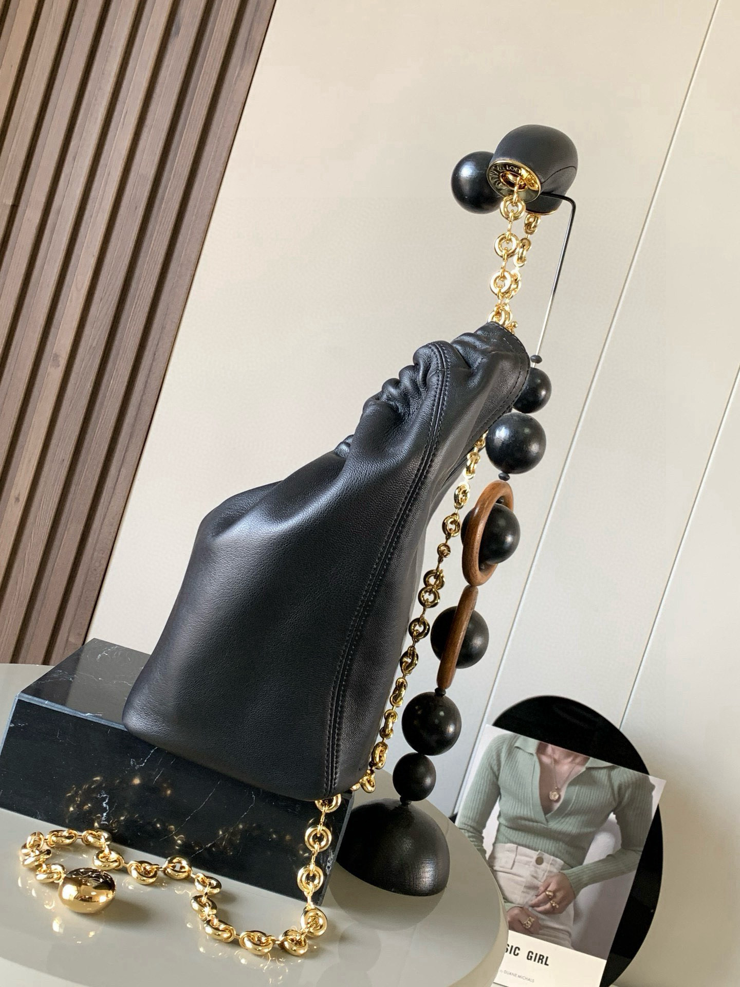 p980。🔥【明星同款】小号纳帕羊皮革Squeeze手袋💄是款精致而柔美的全新手袋💥全新发布的 Squeeze 手袋采用柔软丝滑的Mellow纳帕小羊皮制作而成❤️无衬里结构有效减轻包身自重🌺观感上也更为轻盈⭐️弯月形包口以优雅的褶边收口，营造出轻松又随性的态度👜这款包包还有一大亮点是符合人体工程学的 Squeeze 气囊手柄🌼搭配黄铜打造的精美甜甜圈链条😘可通过链环调节长短或添加延长链，实现手拎、肩背、斜挎等不同背法😻气囊手柄可自由滑动位置以提升舒适度🌻链条底部点缀一枚 Anagram Pebble 吊坠，为包包增添灵动细节⚡️
尺寸：29CM～24CM～10.5CM
款号：9042
颜色：黑色