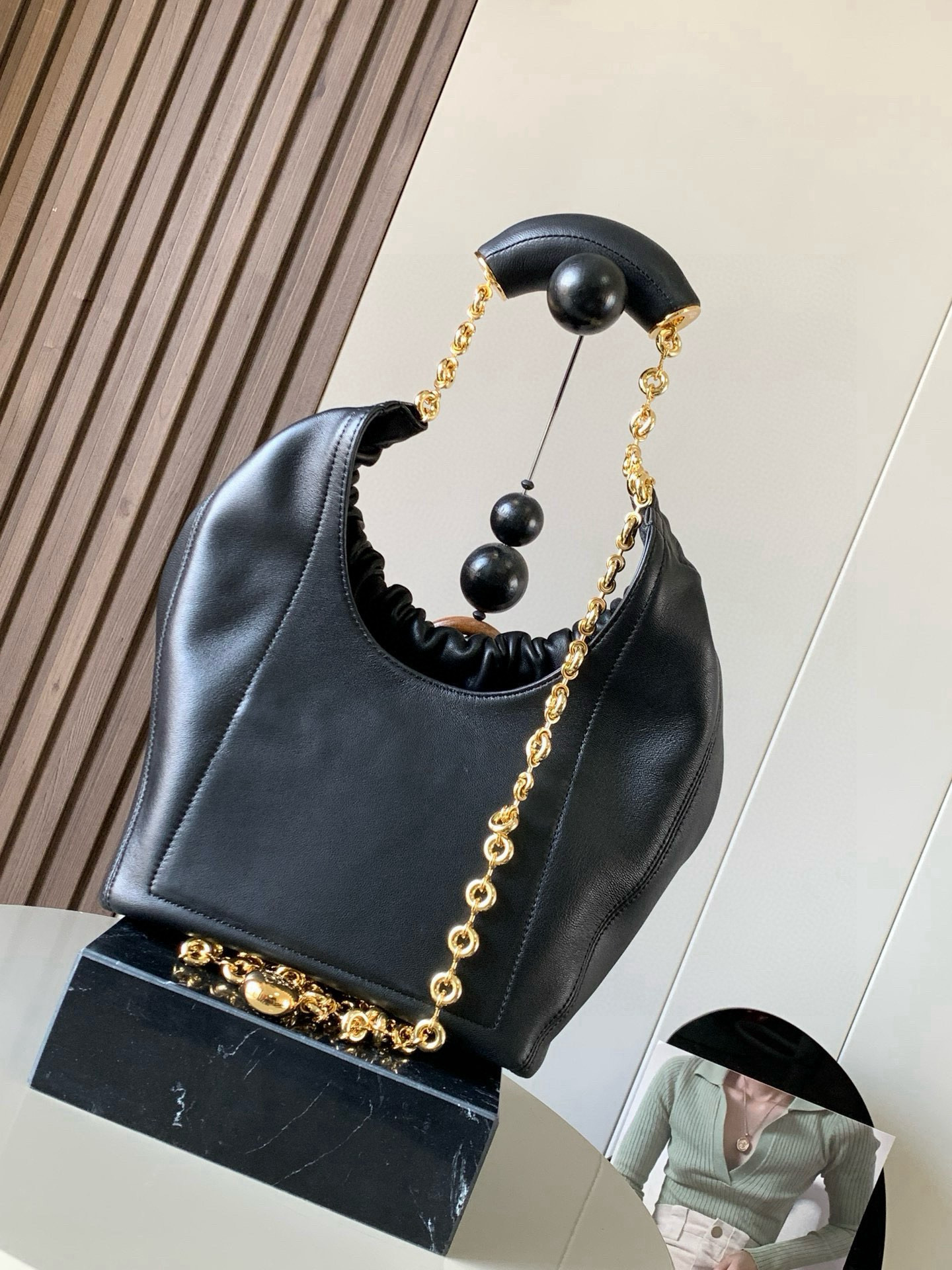 p980。🔥【明星同款】小号纳帕羊皮革Squeeze手袋💄是款精致而柔美的全新手袋💥全新发布的 Squeeze 手袋采用柔软丝滑的Mellow纳帕小羊皮制作而成❤️无衬里结构有效减轻包身自重🌺观感上也更为轻盈⭐️弯月形包口以优雅的褶边收口，营造出轻松又随性的态度👜这款包包还有一大亮点是符合人体工程学的 Squeeze 气囊手柄🌼搭配黄铜打造的精美甜甜圈链条😘可通过链环调节长短或添加延长链，实现手拎、肩背、斜挎等不同背法😻气囊手柄可自由滑动位置以提升舒适度🌻链条底部点缀一枚 Anagram Pebble 吊坠，为包包增添灵动细节⚡️
尺寸：29CM～24CM～10.5CM
款号：9042
颜色：黑色