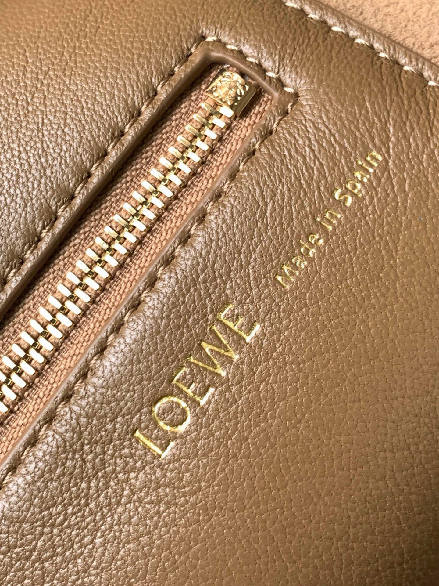 p980。🔥【明星同款】小号纳帕羊皮革Squeeze手袋💄是款精致而柔美的全新手袋💥全新发布的 Squeeze 手袋采用柔软丝滑的Mellow纳帕小羊皮制作而成❤️无衬里结构有效减轻包身自重🌺观感上也更为轻盈⭐️弯月形包口以优雅的褶边收口，营造出轻松又随性的态度👜这款包包还有一大亮点是符合人体工程学的 Squeeze 气囊手柄🌼搭配黄铜打造的精美甜甜圈链条😘可通过链环调节长短或添加延长链，实现手拎、肩背、斜挎等不同背法😻气囊手柄可自由滑动位置以提升舒适度🌻链条底部点缀一枚 Anagram Pebble 吊坠，为包包增添灵动细节⚡️
尺寸：29CM～24CM～10.5CM
款号：9042
颜色：橡木棕