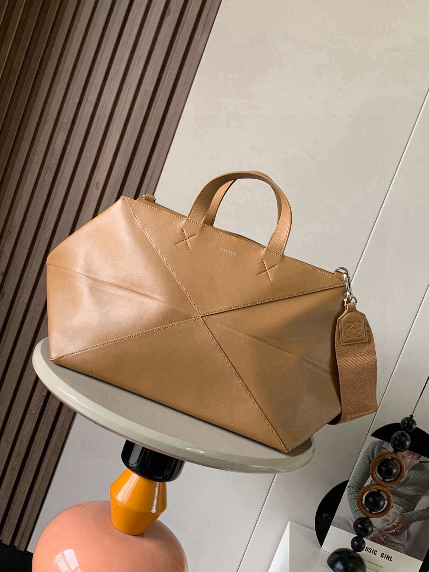 NO:639852,The new extra large glossy cowhide Puzzle Fold handbag draws inspiration from the geometric lines of the brand's classic handbag series and reinterprets it with panels rich in geometric architectural beauty. It can be completely folded and can be described as a travel companion. The brand uses creative ideas to create a soft and lightweight handbag with a low-key and elegant LOEWE brand logo. This extra large version is made of glossy cowhide. * Can be carried on the shoulder or hand * Suede lining * LOEWE bronzing Style No. 9055  Size 59cm～25.5cm～25cm Color oak brown, Loewe, loewe, loewe, cowhide19860909新款特大号亮面牛皮革Puzzle Fold 手袋从品牌经典手袋系列的几何线条汲取灵感以富含几何建筑美感的镶片重新诠释,能完全折叠,可谓旅行良伴品牌运用创意巧思打造柔软轻盈的手袋搭配低调雅致的 LOEWE 品牌标志.此特大号版本采用亮面牛皮革制成.*可肩背和手提＊绒面革衬里＊ LOEWE 烫金 款号9055 尺寸59cm～25.5cm～25cm 颜色橡木棕,罗意威,loewe,loewe,cowhide,Bag