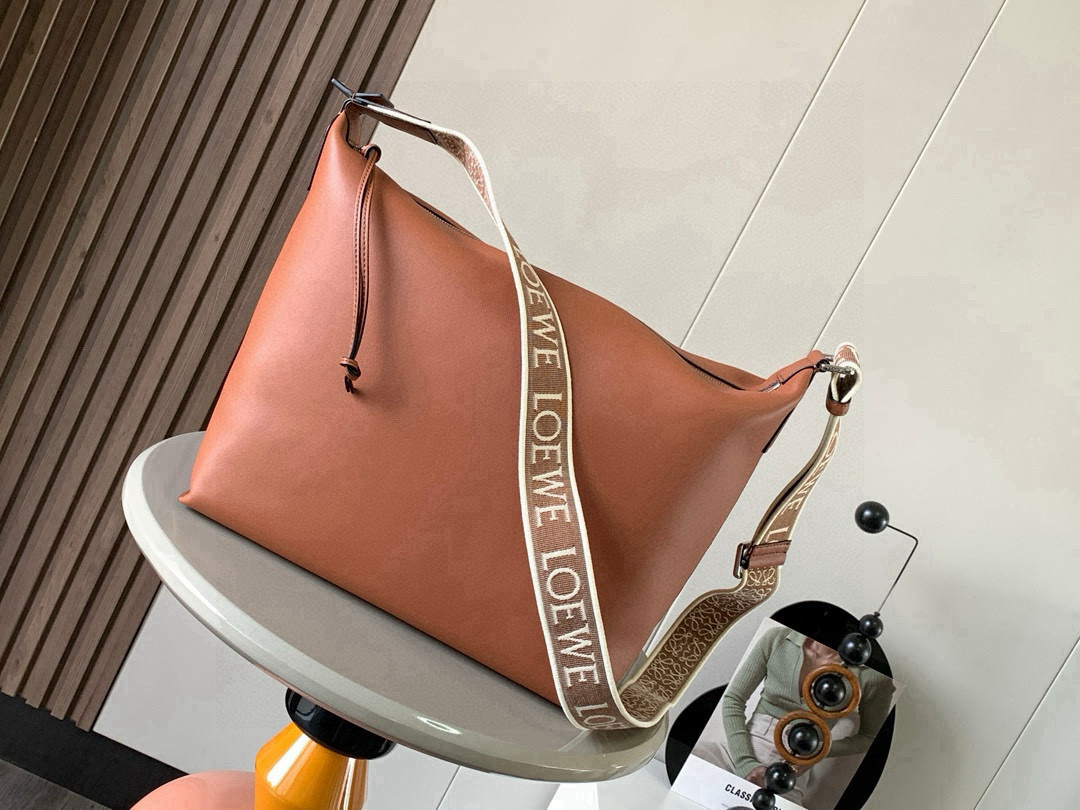 NO:670934,The Cubi crossbody bag makes a stunning appearance. This time, the Cubi is released. It is really surprising. It is equipped with a jacquard adjustable shoulder strap that feels soft on the skin, has a large capacity and is highly functional. It can be worn on one shoulder and under the armpit, and can be used as a gym bag. It is also a luggage bag for short trips. It is also very popular. The Cubi is really a good bag with very high overall quality.  The crossbody bag is a spacious and soft handbag that can easily adapt to the body shape. This version is made of soft and smooth cow leather, with a jacquard shoulder strap. It can be worn cross-body or on the shoulder. Adjustable shoulder strap. Zipper closure with cow leather zipper pull. Internal slip pocket. Can hold a 13-inch laptop. Size 44～30～18CM. Style No. 9010. Color Brown, Loewe, loewe, satchels, crossbody bags, cowhide19860909Cubi斜挎包惊艳亮相这次出了Cubi 真是让人惊喜配有提花可调节肩带手感亲肤柔和容量大功能性强 可以单肩腋下斜挎 可当健身包使用作为短途旅行的行李袋也是非常出圈、出片的真的是一只综合素质非常高的好包包Cubi 斜挎包是一款宽敞且柔软的手袋,可轻松适应体形此版本采用柔软光滑的牛皮革制成,搭配提花肩带.斜挎或肩背.可调节肩带.拉链开合带牛皮革拉链头.内部插袋.可放13寸笔记本电脑 尺寸44～30～18CM 款号9010 颜色棕色,罗意威,loewe,satchels,crossbody bags,cowhide,Bag