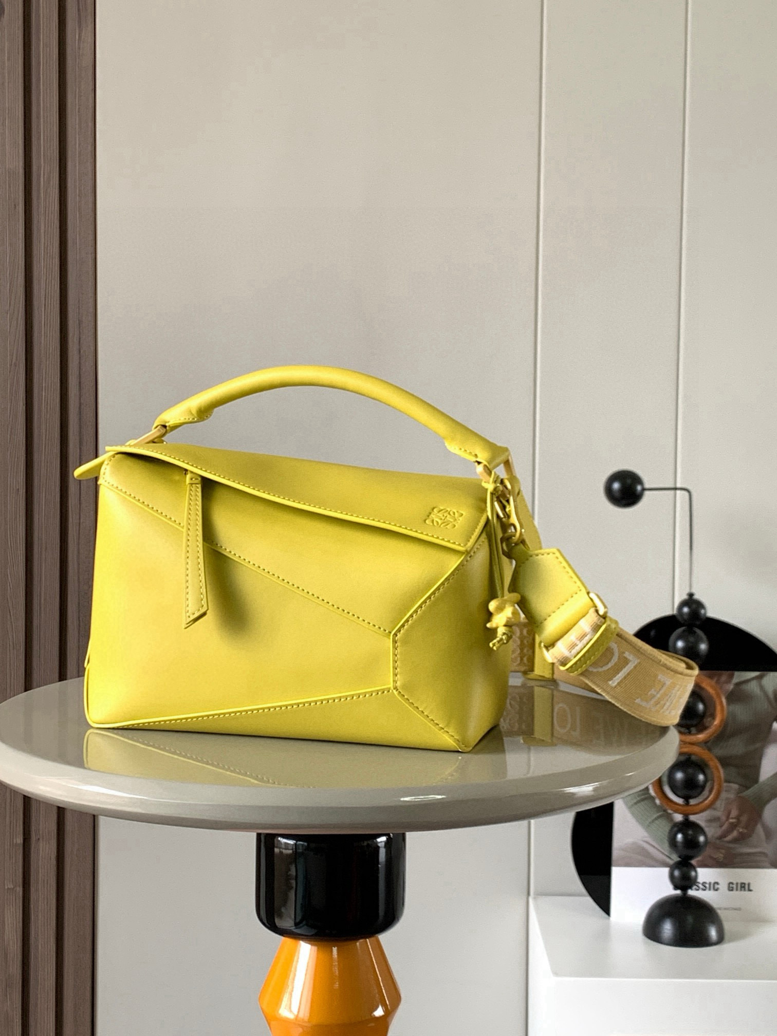 NO:670918,Ceramic bunny geometric bag 24C MPuzzle handbag Original imported calfskin plain Luojia popular geometric bag The Puzzle handbag is the first handbag launched by creative director Jonathan Anderson for L0EWE. The rectangular shape and precise cutting technology created the Puzzle  The unique geometric lines are inspired by the traditional Chinese monochrome glaze ceramics, which perfectly interprets the extreme beauty of nature. The monochrome glaze series is made of one-color satin cowhide from the bag body to the hardware, which is smooth, supple and clean. It is paired with highly recognizable embroidered wide shoulder straps, exuding a natural sense of high-end fashion. The same-color ceramic bunny pendant is very chic, absolutely stunning!  Size 24CM～16CM～10CM Style number 9001 Color yellow, Loewe, loewe, loewe, cowhide19860909陶瓷小兔款几何包24CMPuzzle手袋原厂进口小牛皮平纹罗家爆款几何包Puzzle 手袋是创意总监乔纳森·安德森为 L0EWE 推出的首款手提包,长方体形状和精确的切割技术创造了 Puzzle 独特的几何线条灵感来自中国传统的单色釉陶瓷完美诠释美到极致是自然～单色釉系列从包身到五金通体一色缎面牛皮材质光滑柔顺干净利落配上辨识度极高的刺绣宽肩带,散发着一种浑然天成的高级时髦感配上同色系陶瓷兔子挂饰十分走心,绝了！ 尺寸24CM～16CM～10CM 款号9001 颜色黄色,罗意威,loewe,loewe,cowhide,Bag