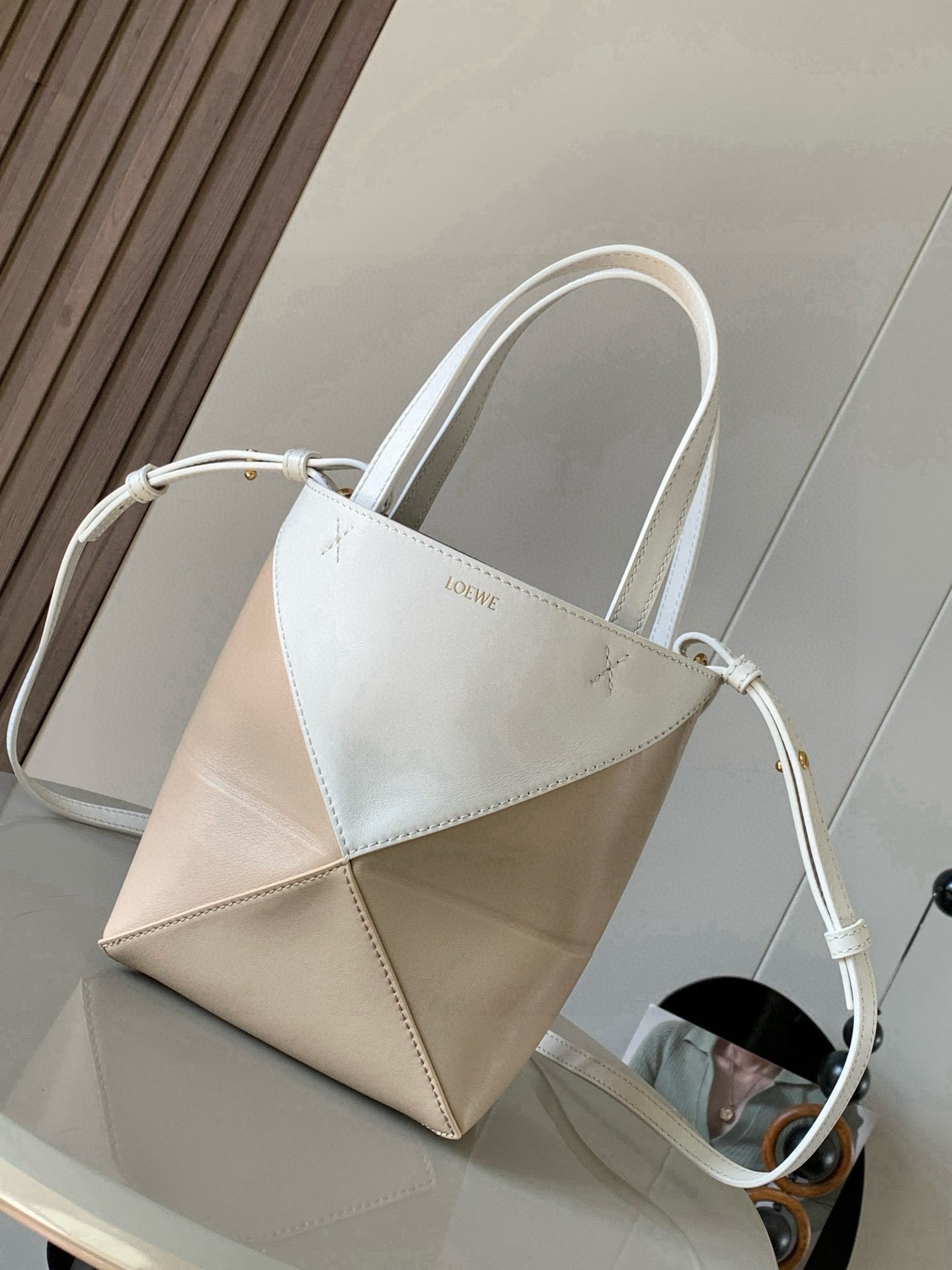 NO:670941,The new glossy cow leather mini puzzle Fold handbag plays with geometric patterns again. It has been a long time since I have seen such a practical and design tote bag. This one continues the geometric aesthetics of the Puzzle series. Inspired by the origami bag, this Puzzle Fold tote can switch between three-dimensional and flat surfaces at will. The leather is very delicate and shiny. It is ultra-light in weight, and the Puzzle can be folded.  The Fold handbag draws inspiration from the geometric lines of the brand's classic handbag series and uses creative ingenuity to reinterpret it into a fashionable tote bag that can be completely folded and is a good travel companion. This mini version is made of soft glossy cowhide. Size 20CM ~ 16.5CM ~ 9CM. Style number 9030. Color: white, gray, beige, Loewe, loewe, totes, cowhide19860909新款亮面牛皮革迷你号puzzle Fold手袋又把几何图形玩出花了很久没见过这么实用又设计感满满的托特包了这款延续了Puzzle系列的几何美学以折纸包为灵感,让这只 Puzzle Fold tote 在立体和平面随意切换皮质都很细腻光泽本身自重超轻,外加可以折叠Puzzle Fold手袋从品牌经典手袋系列的几何线条汲取灵感运用创意巧思将其重新诠释为一款时尚的托特袋,能完全折叠是旅行良伴.这个迷你号版本采用柔软的亮面牛皮革打造 尺寸20CM～16.5CM～9CM 款号9030 颜色大白灰米杏,罗意威,loewe,totes,cowhide,Bag