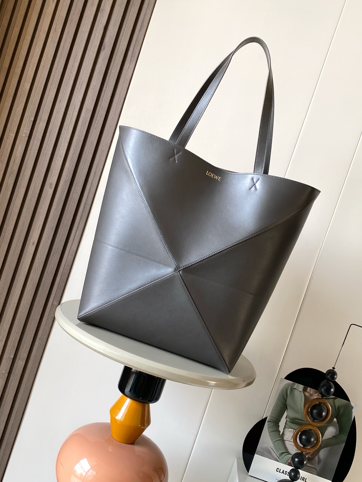 NO:688375,Large new shiny cow leather shopping bag puzzle Fold handbag large geometric pattern It has been a long time since I have seen such a practical and design tote bag. This continues the geometric aesthetics of the Puzzle series and is inspired by origami bags. This Puzzle Fold tote  I freely switch between three-dimensional and flat upper body sizes for your reference. The large size has a more friendly capacity, and the small size is very cute. The leather is very delicate and shiny. It is super light in weight. In addition, it can be folded, which is perfect for commuting with a computer, or for people like me who often travel on business and can easily store it in their luggage. Puzzle  The Fold handbag draws inspiration from the geometric lines of the brand's classic handbag series and uses creative ingenuity to reinterpret it into a fashionable tote bag that can be completely folded and is a good travel companion. This large version is made of soft glossy cow leather. Size 42CM ~ 41CM ~ 18CM. Style No. 9033. Color: dark gray coffee, Loewe, loewe, totes, cowhide19860909大号新款亮面牛皮革购物袋puzzle Fold手袋大号几何图形玩出花了很久没见过这么实用又设计感满满的托特包了这款延续了Puzzle系列的几何美学以折纸包为灵感,让这只 Puzzle Fold tote 在立体和平面随意切换上身了两个尺码给大家参考哦大号容量更友好,小号很可爱,皮质都很细腻光泽本身自重超轻,外加可以折叠太适合平时带电脑通勤,或是像我一样经常出差旅行不费力的收纳进行李箱,Puzzle Fold手袋从品牌经典手袋系列的几何线条汲取灵感运用创意巧思将其重新诠释为一款时尚的托特袋,能完全折叠是旅行良伴.这个大号版本采用柔软的亮面牛皮革打造 尺寸42CM～41CM～18CM 款号9033 颜色深灰咖,罗意威,loewe,totes,cowhide,Bag