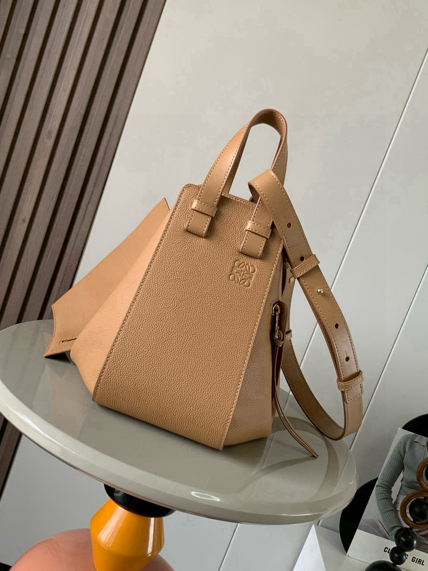 NO:688712,Small Hammock Bag in Soft Grained Cow Leather A versatile bag with soft side wraps that release the sides to change shape. Loop straps allow the bag to be worn in a variety of ways. This smaller version is crafted in soft grained Cow Leather *Small Hammock  Can hold, for example, a large wallet, all sizes of mobile phones and sunglasses *Cross-body, shoulder or via top handle *Detachable and adjustable shoulder strap *Internal hook closure *Two internal slip pockets, one external zippered pocket  color toffee,loewe,loewe,wallets,cowhide19860909小号柔软粒面牛皮革 Hammock 手袋带有柔软侧面包身的多功能手袋可释放侧面来改变形状.环状带子可以使手袋有多种佩戴方式这个小尺寸版本采用柔软粒面牛皮革制成 ＊小号 Hammock 可以容纳例如一只大号钱包所有尺寸的手机和太阳镜＊斜挎,肩背或通过顶部提手携带＊可拆卸可调节肩带＊内部钩扣封口＊两个内部插袋,一个外部拉链口袋＊可以使用肩带和个性化挂饰进行定制＊人字纹棉质帆布衬里* Anagram 压纹 尺寸30cm～25cm～14cm 款号9060 颜色太妃糖,罗意威,loewe,wallets,cowhide,Bag