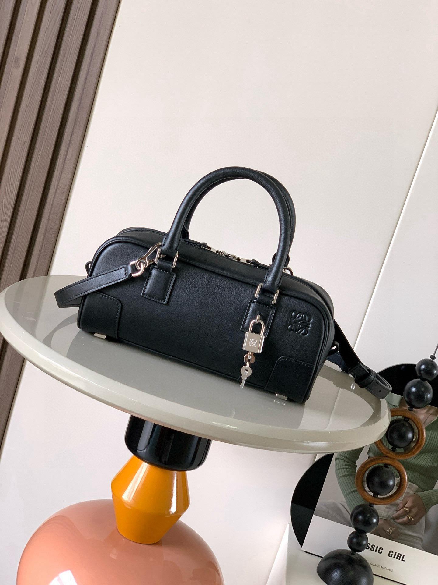 NO:719416,The new celebrity handbag Amazona is an iconic handbag originally launched by LOEWE in the 1970s, featuring exquisite proportions and key details including the Anagram  The short style with engraved padlock is made of nappa cow leather * Can be worn on the shoulder, cross-body or hand-held * Detachable and adjustable shoulder strap * Zipper closure, cow leather zipper pull * An internal zipper compartment, a slip pocket, a padlock key storage bag * The bottom of the bag is protected by metal feet * Gold suede lining * Anagram embossed Size 23cm～10cm～11cm Style No. 9085  Color black silver lock,loewe,loewe,loewe,cowhide19860909新款明星同款手袋 Amazona 是 LOEWE 最初于1970年代推出的标志性手袋,采用精致比例和关键细节包括 Anagram 镌刻挂锁短款以纳帕牛皮革打造而成＊可肩背、斜挎或手提＊可拆卸可调节肩带＊拉链开合,牛皮革拉链头＊一个内部拉链隔层一个插袋,一个挂锁钥匙收纳袋＊包底以金属脚钉保护＊金色绒面革衬里* Anagram 压纹 尺寸23cm～10cm～11cm 款号9085 颜色黑色银锁,罗意威,loewe,loewe,cowhide,Bag