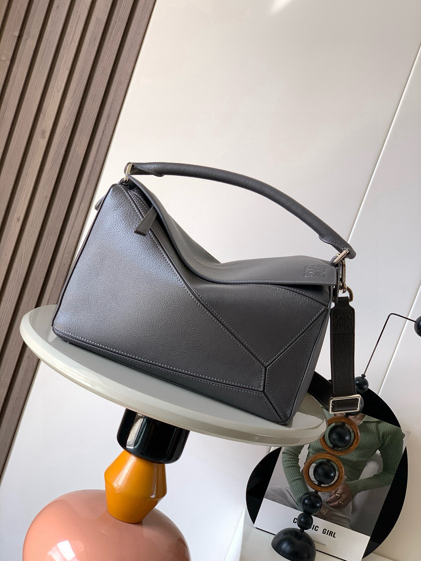 NO:719456,The new Puzzle size handbag Puzzle handbag is the creative director of Jonathan.  The first handbag launched by Jonathan Anderson, the cuboid shape and precise cutting techniques create the unique geometric lines of the Puzzle. This version is made from glossy cow leather with overlapping edges. * Can be worn on the shoulder, cross-body or handheld.  Anagram embossing meets the needs of different occasions. Unisex. Size 33cm～14.7cm～21.5cm. Style No. 9095. Color: gray coffee, Loewe, loewe, cowhide19860909新款Puzzle尺寸手袋Puzzle 手袋是创意总监乔纳森．安德森（ Jonathan Anderson）推出的首款手提包长方体形状和精确的切割技术创造了 Puzzle 独特的几何线条此版本采用亮面牛皮革制成饰有重叠边缘＊可肩背、斜挎或手提＊可拆卸可调节肩带＊外部后方拉链袋和两个内部插袋＊拉链开合牛皮革拉链头＊可以使用肩带和个性化挂饰进行定制＊绒面革衬里＊ Anagram 压纹 满足不同场合需求男女通用 尺寸33cm～14.7cm～21.5cm 款号9095 颜色灰咖,罗意威,loewe,cowhide,Bag