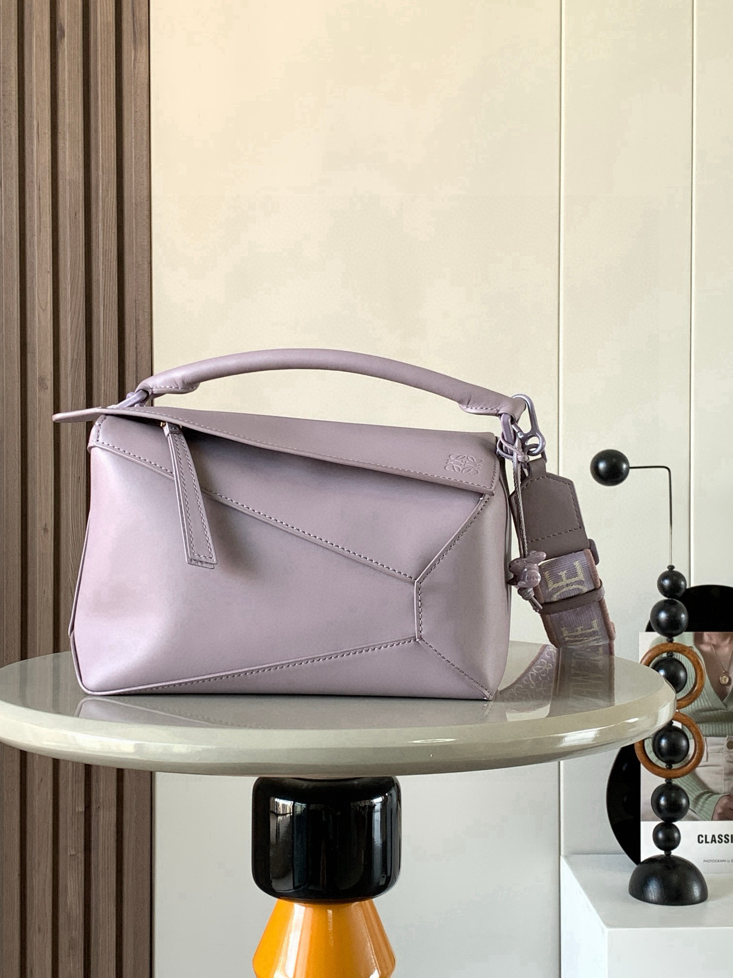 NO:719480,Ceramic bunny geometric bag 24C MPuzzle handbag Original imported calfskin plain Luojia popular geometric bag The Puzzle handbag is the first handbag launched by creative director Jonathan Anderson for L0EWE. The rectangular shape and precise cutting technology created the Puzzle  The unique geometric lines are inspired by the traditional Chinese monochrome glaze ceramics, which perfectly interprets the extreme beauty of nature. The monochrome glaze series is made of one-color satin cowhide from the bag body to the hardware, which is smooth, supple and clean. It is paired with highly recognizable embroidered wide shoulder straps, exuding a natural sense of high-end fashion. The same-color ceramic bunny pendant is very chic, absolutely stunning!  Size 24CM～16CM～10CM Style number 9001 Color light purple, Loewe, loewe, loewe, cowhide19860909陶瓷小兔款几何包24CMPuzzle手袋原厂进口小牛皮平纹罗家爆款几何包Puzzle 手袋是创意总监乔纳森·安德森为 L0EWE 推出的首款手提包,长方体形状和精确的切割技术创造了 Puzzle 独特的几何线条灵感来自中国传统的单色釉陶瓷完美诠释美到极致是自然～单色釉系列从包身到五金通体一色缎面牛皮材质光滑柔顺干净利落配上辨识度极高的刺绣宽肩带,散发着一种浑然天成的高级时髦感配上同色系陶瓷兔子挂饰十分走心,绝了！ 尺寸24CM～16CM～10CM 款号9001 颜色浅紫,罗意威,loewe,loewe,cowhide,Bag