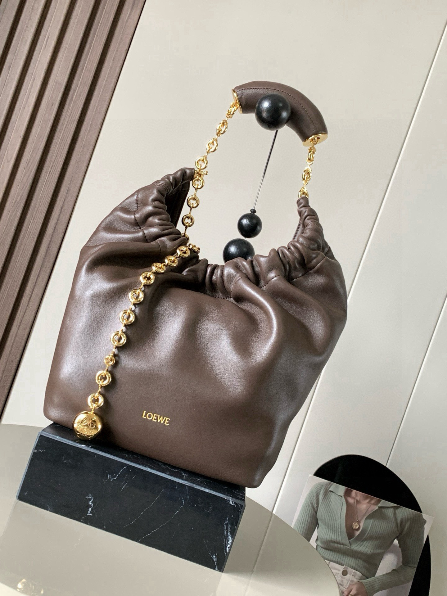 NO:719528,[Celebrity Style] Small Nappa Lamb Leather Squeeze Handbag is a refined and feminine new handbag. The newly released Squeeze Handbag is made of soft and silky Mellow Nappa lambskin. The unlined structure effectively reduces the weight of the bag and makes it lighter in appearance. The crescent-shaped bag mouth is closed with elegant ruffles, creating a relaxed and casual attitude. Another highlight of this bag is the ergonomic Squeeze  The airbag handle is paired with a delicate donut chain made of brass. The length can be adjusted through the chain link or an extension chain can be added to realize different carrying methods such as hand carry, shoulder carry, and crossbody. The airbag handle can slide freely to improve comfort. An Anagram Pebble pendant is embellished at the bottom of the chain to add smart details to the bag. Size 29CM～24CM～10.5CM Style No. 9042 Color Chocolate, Loewe, Loewe, Sheepskin19860909【明星同款】小号纳帕羊皮革Squeeze手袋是款精致而柔美的全新手袋全新发布的 Squeeze 手袋采用柔软丝滑的Mellow纳帕小羊皮制作而成无衬里结构有效减轻包身自重观感上也更为轻盈弯月形包口以优雅的褶边收口,营造出轻松又随性的态度这款包包还有一大亮点是符合人体工程学的 Squeeze 气囊手柄搭配黄铜打造的精美甜甜圈链条可通过链环调节长短或添加延长链,实现手拎、肩背、斜挎等不同背法气囊手柄可自由滑动位置以提升舒适度链条底部点缀一枚 Anagram Pebble 吊坠,为包包增添灵动细节 尺寸29CM～24CM～10.5CM 款号9042 颜色巧克力,罗意威,loewe,sheepskin,Bag