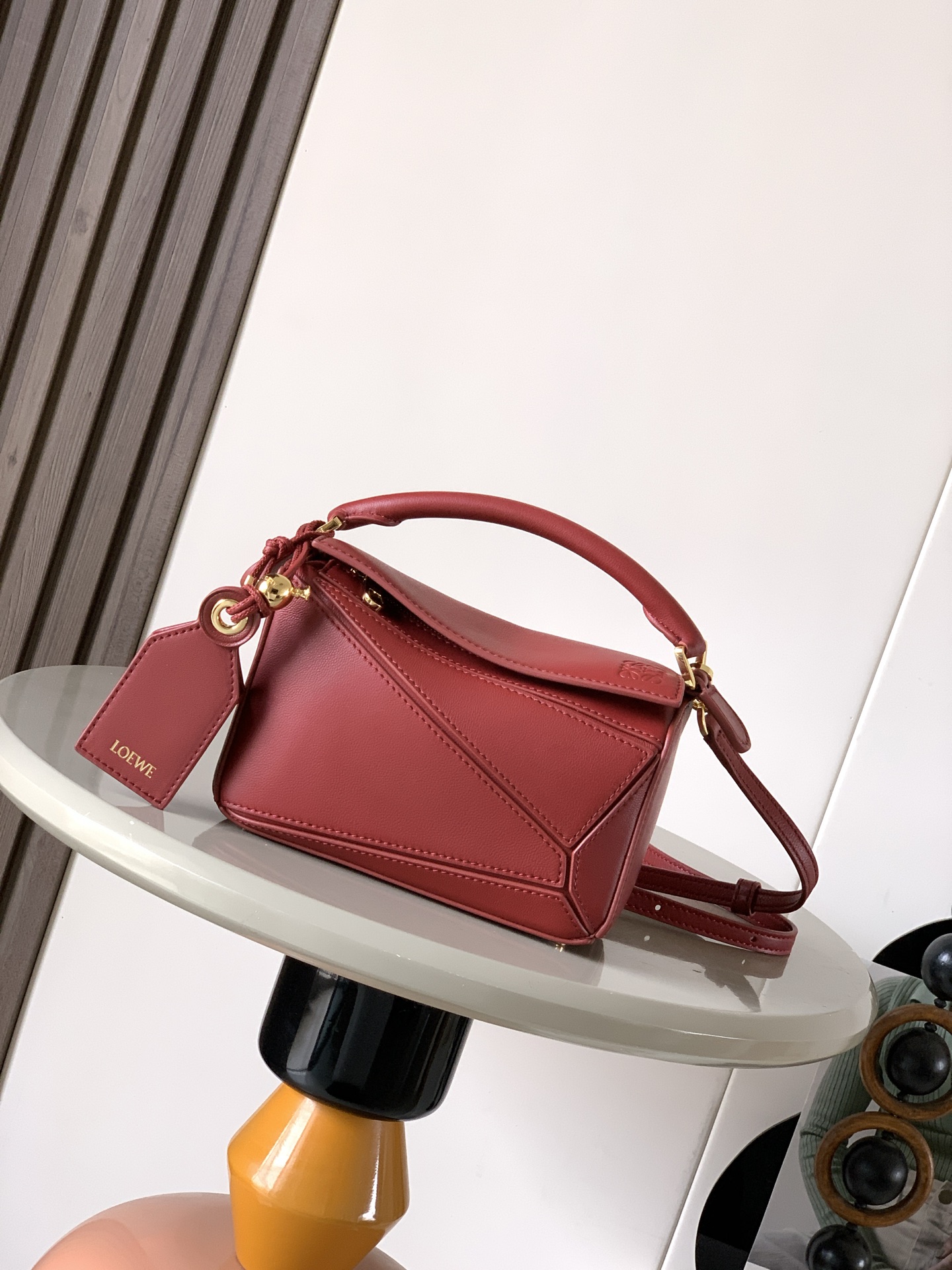 NO:719554,New version of the Geometric Bag Mini Nappa Lamb Leather Featherlight Puzzle Bag,  Original imported Napa calfskin outlines a cuboid shape with unique geometric lines. The soft and lightweight Napa leather injects a casual and lazy style into the handbag. *Can be carried on the shoulder, crossbody or handheld* Detachable and adjustable shoulder strap, decorated with rotating buckle*Zip  Closure, articulated zipper pull * One external zipped back pocket, one internal slip pocket * Removable, with secret pocket and balloon dice * Rectangular metal feet * This smaller version is made from soft Nappa calf leather * Small Puzzle  Can hold, for example, a large wallet, mobile phones and sunglasses of all sizes. Can be carried diagonally, on the shoulder, in the hand or by the top handle19860909新版本几何包迷你纳帕羊皮革 Featherlight Puzzle 手袋, 原厂进口纳帕小牛皮以别具一格的几何线条勾勒长方体造型.柔软轻盈的纳帕皮革为手袋注入随性慵懒的风格.*可肩背、斜挎或手提*可拆卸可调节肩带,饰有旋转卡扣*拉链开合,铰接式拉链头*一个外部拉链后袋,一个内部插袋*可拆卸,饰有隐秘口袋和气球骰子*长方形金属脚钉*这个小尺寸版本采用柔软纳帕小牛皮革制成＊小号Puzzle 可以容纳例如一只大号钱包所有尺寸的手机和太阳镜斜、肩背、手拿或顶部提手携带＊可拆卸 颜色深红 款号9098 尺寸18CM～12.5CM～7.5CM,罗意威,loewe,wallets,cowhide,sheepskin,Bag