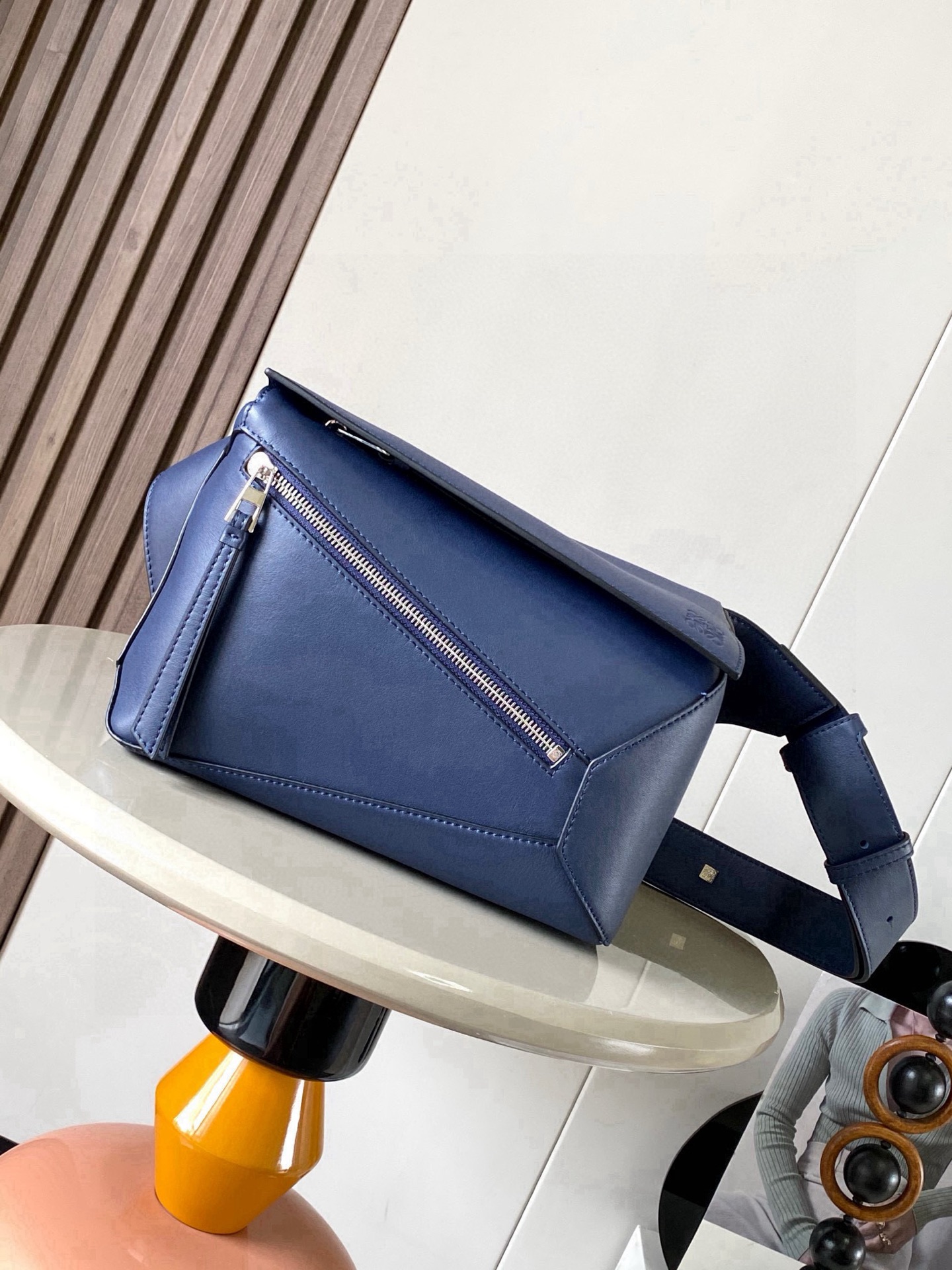 NO:719613,The new small classic cow leather Puzzle waist bag has a rectangular shape and precise cutting technology to create Puzzle's unique geometric lines. This small waist bag is made of classic cow leather. The leather is soft and lightweight, and the shape is low-key and recognizable. It can be worn with the back, whether it is business or leisure. I found a puzzle waist bag, which is relatively classic and puzzle is relatively niche. This waist bag removes the handle of the classic puzzle and puts the classic puzzle  The rear zipper bag has been moved to the front belt and has become a non-detachable latch buckle wide belt. In addition to retaining the classic puzzle casual and artistic basic bag shape, the fork adds a cool mechanical feel. It is also classic and versatile. It not only has a considerable capacity but also has a better upper body proportion. Shoulder or crossbody, adjustable shoulder strap, equipped with metal buckle closure. Size 24CM～16CM～10.5CM. Style No. 9114. Color: navy blue, Loewe, loewe, cowhide.19860909新款小号经典牛皮革 Puzzle 腰包长方体形状和精确的切割技术创造了Puzzle 独特的几何线条这款小号腰包采用经典牛皮革制成皮质柔软轻便,造型低调有辨识度不管是商务还是休闲都可以搭配后来叉发现一款 puzzle腰包,相对经典,puzzle 来说比较小众此款腰包去掉了经典puzzle的手柄把经典puzzle 后面的后置拉链袋移到了前面腰带也变成不可拆卸插销扣宽腰带保留经典puzzle随性文艺的基本包型外,叉增加了一份酷酷的机械感同样经典百搭 不仅容量可观而且上身比例更好.肩背或斜挎 ,可调节肩带,配有金属搭扣开合 尺寸24CM～16CM～10.5CM 款号9114 颜色海军蓝,罗意威,loewe,cowhide,Bag