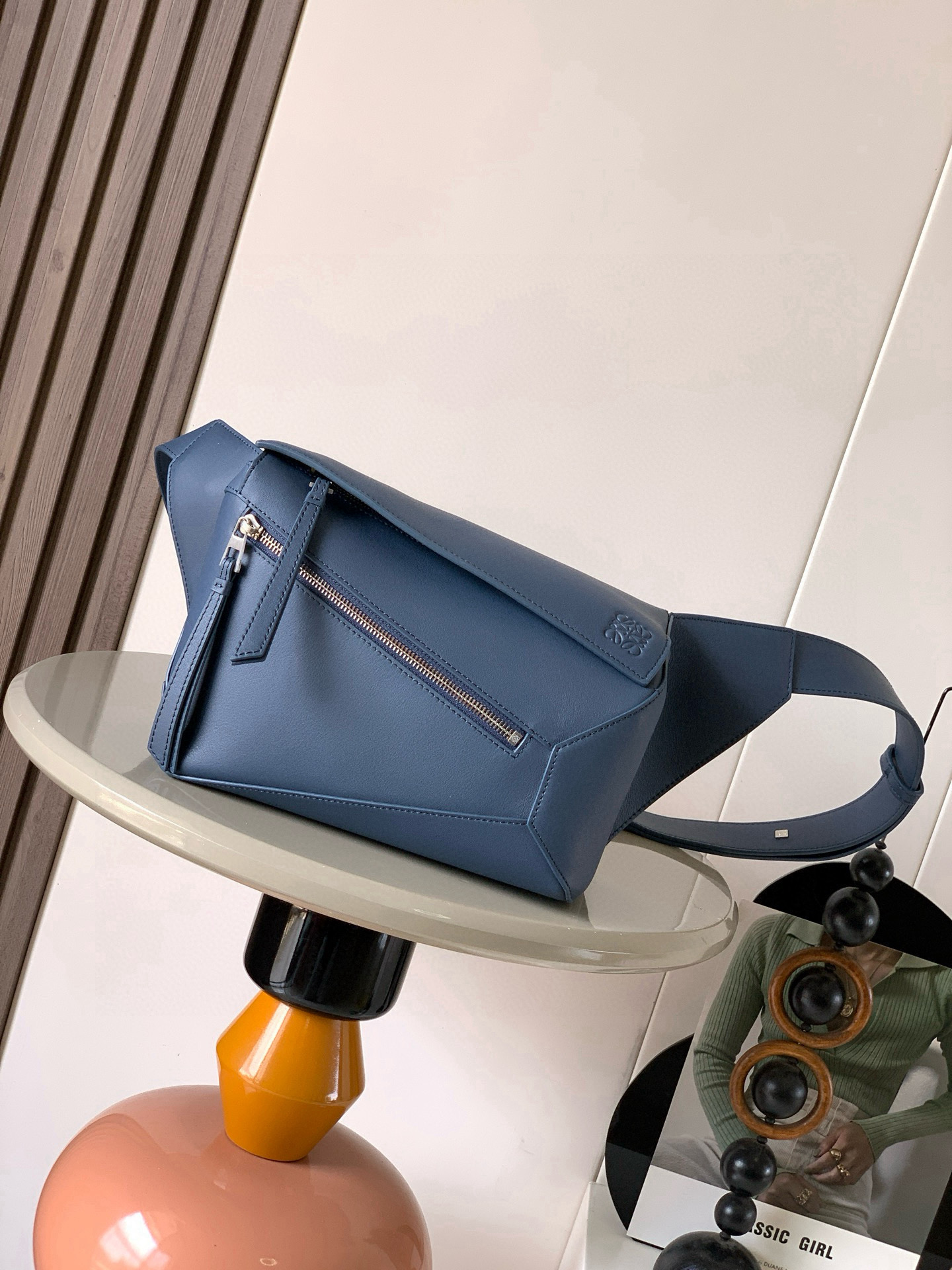 NO:719593,The new small classic cow leather Puzzle waist bag has a rectangular shape and precise cutting technology to create Puzzle's unique geometric lines. This small waist bag is made of classic cow leather. The leather is soft and lightweight, and the shape is low-key and recognizable. It can be worn with the back, whether it is business or leisure. I found a puzzle waist bag, which is relatively classic and puzzle is relatively niche. This waist bag removes the handle of the classic puzzle and puts the classic puzzle  The rear zipper bag has been moved to the front and the belt has also become a non-detachable latch buckle. The wide belt retains the classic puzzle casual and artistic basic bag shape, and the fork adds a cool mechanical feel. It is also classic and versatile. It not only has a considerable capacity but also has a better upper body proportion. It can be carried on the shoulder or crossbody, with an adjustable shoulder strap and a metal buckle opening and closing. Size 24CM ~ 16CM ~ 10.5CM. Style No. 9114  Color indigo,loewe,loewe,cowhide19860909新款小号经典牛皮革 Puzzle 腰包长方体形状和精确的切割技术创造了Puzzle 独特的几何线条这款小号腰包采用经典牛皮革制成皮质柔软轻便,造型低调有辨识度不管是商务还是休闲都可以搭配后来叉发现一款 puzzle腰包,相对经典,puzzle 来说比较小众此款腰包去掉了经典puzzle的手柄把经典puzzle 后面的后置拉链袋移到了前面腰带也变成不可拆卸插销扣宽腰带保留经典puzzle随性文艺的基本包型外,叉增加了一份酷酷的机械感同样经典百搭 不仅容量可观而且上身比例更好.肩背或斜挎 ,可调节肩带,配有金属搭扣开合 尺寸24CM～16CM～10.5CM 款号9114 颜色靛蓝色,罗意威,loewe,cowhide,Bag