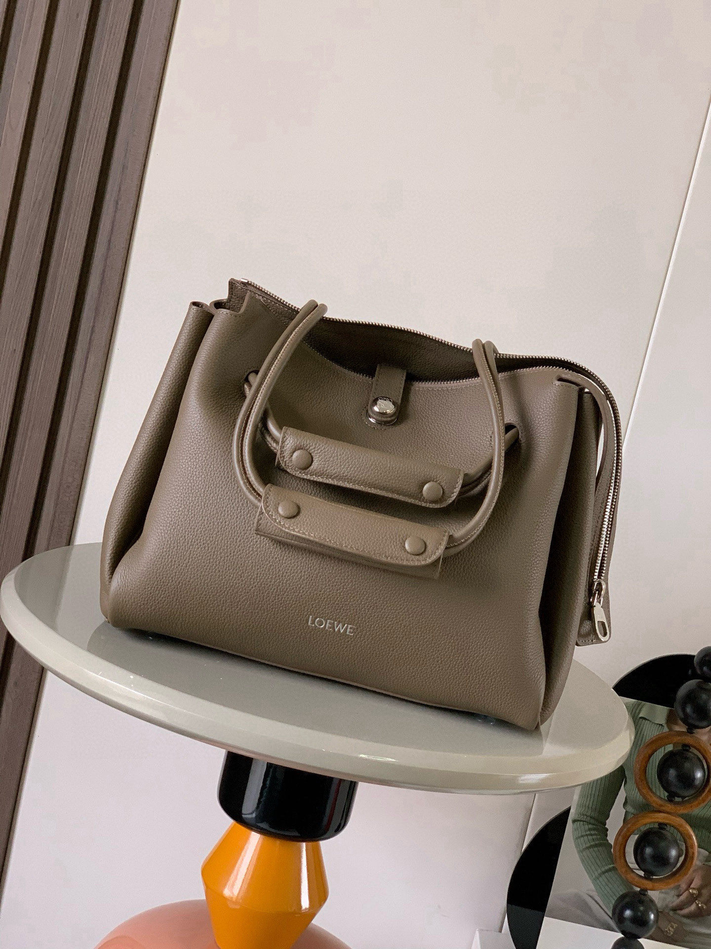 NO:719639,Medium Madrid bag in soft calfskin Madrid has a soft structured trapezoidal shape with gusseted design, adjustable handles and Pebble magnetic closure This medium version is made of soft calfskin *Can be worn on the shoulder, cross-body or by hand*Adjustable shoulder strap with leather extension *AnagramPebble magnetic zipper closure*One zipped interior pocket *Anagram Pebble metal feet *Nappa sheepskin lining  Size 28.5CM～23CM～11CM Style No. 9147 Color Taupe Li, Loewe, loewe, cowhide, sheepskin19860909中号柔软牛皮革 Madrid手袋Madrid 具有柔软的结构感梯形造型采用角撑设计,搭配可调节提手和 Pebble 磁扣此中号版本采用柔软牛皮革制成*可肩背、斜挎或手提*可调节肩带,搭配皮革延长带 *AnagramPebble 磁扣开合拉链开合*一个拉链内袋 *Anagram Pebble金属脚钉*纳帕羊皮革衬里 尺寸28.5CM～23CM～11CM 款号9147 颜色灰褐色荔,罗意威,loewe,cowhide,sheepskin,Bag