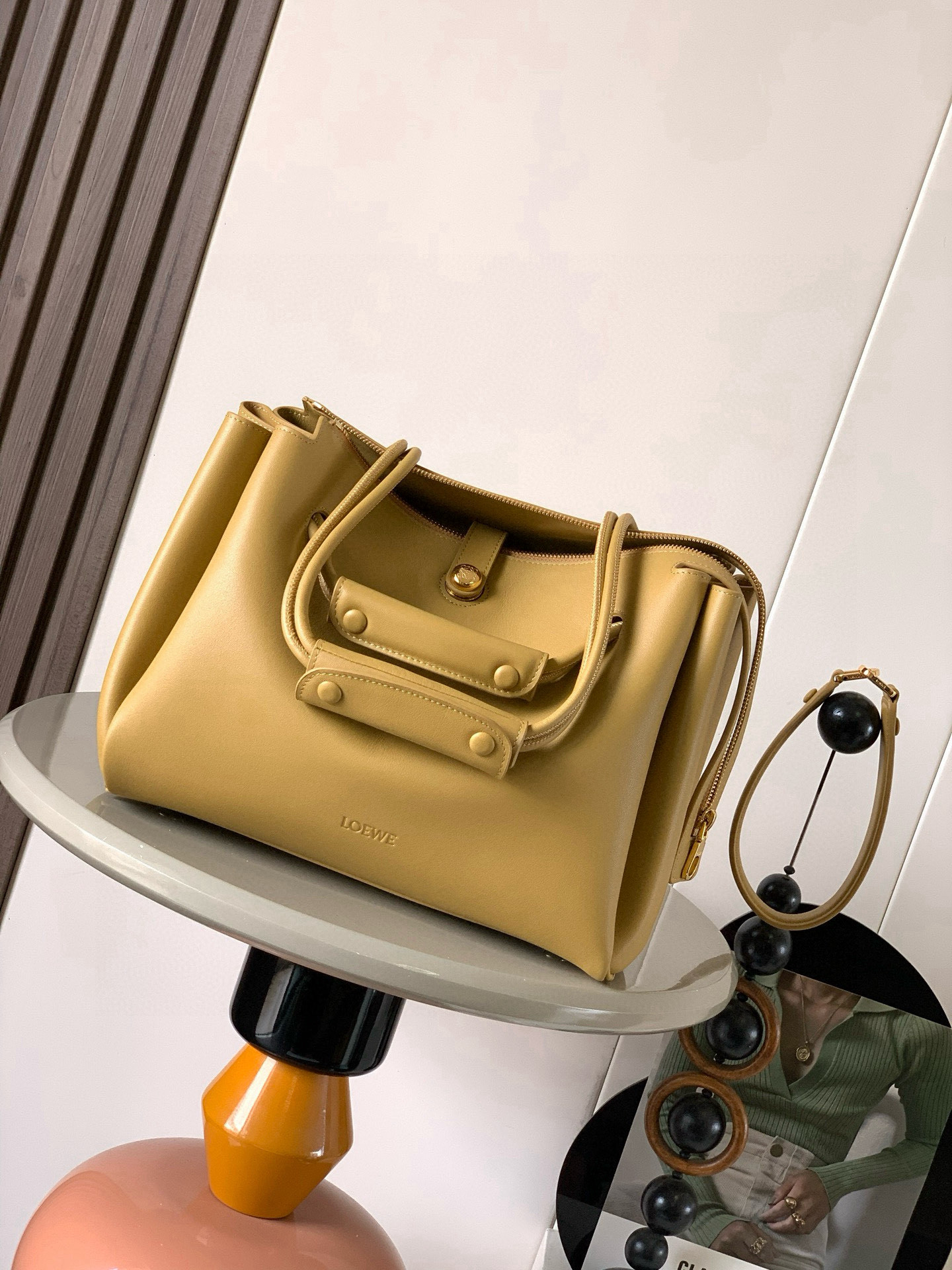 NO:719641,Medium Madrid bag in soft calfskin Madrid has a soft structured trapezoidal shape with gusseted design, adjustable handles and Pebble magnetic closure This medium version is made of soft calfskin *Can be worn on the shoulder, cross-body or by hand*Adjustable shoulder strap with leather extension *AnagramPebble magnetic zipper closure*One zipped interior pocket *Anagram Pebble metal feet *Nappa sheepskin lining  Size 28.5CM～23CM～11CM Style number 9147 Color: warm sandy yellow, Loewe, loewe, cowhide, sheepskin19860909中号柔软牛皮革 Madrid手袋Madrid 具有柔软的结构感梯形造型采用角撑设计,搭配可调节提手和 Pebble 磁扣此中号版本采用柔软牛皮革制成*可肩背、斜挎或手提*可调节肩带,搭配皮革延长带 *AnagramPebble 磁扣开合拉链开合*一个拉链内袋 *Anagram Pebble金属脚钉*纳帕羊皮革衬里 尺寸28.5CM～23CM～11CM 款号9147 颜色暖沙黄,罗意威,loewe,cowhide,sheepskin,Bag