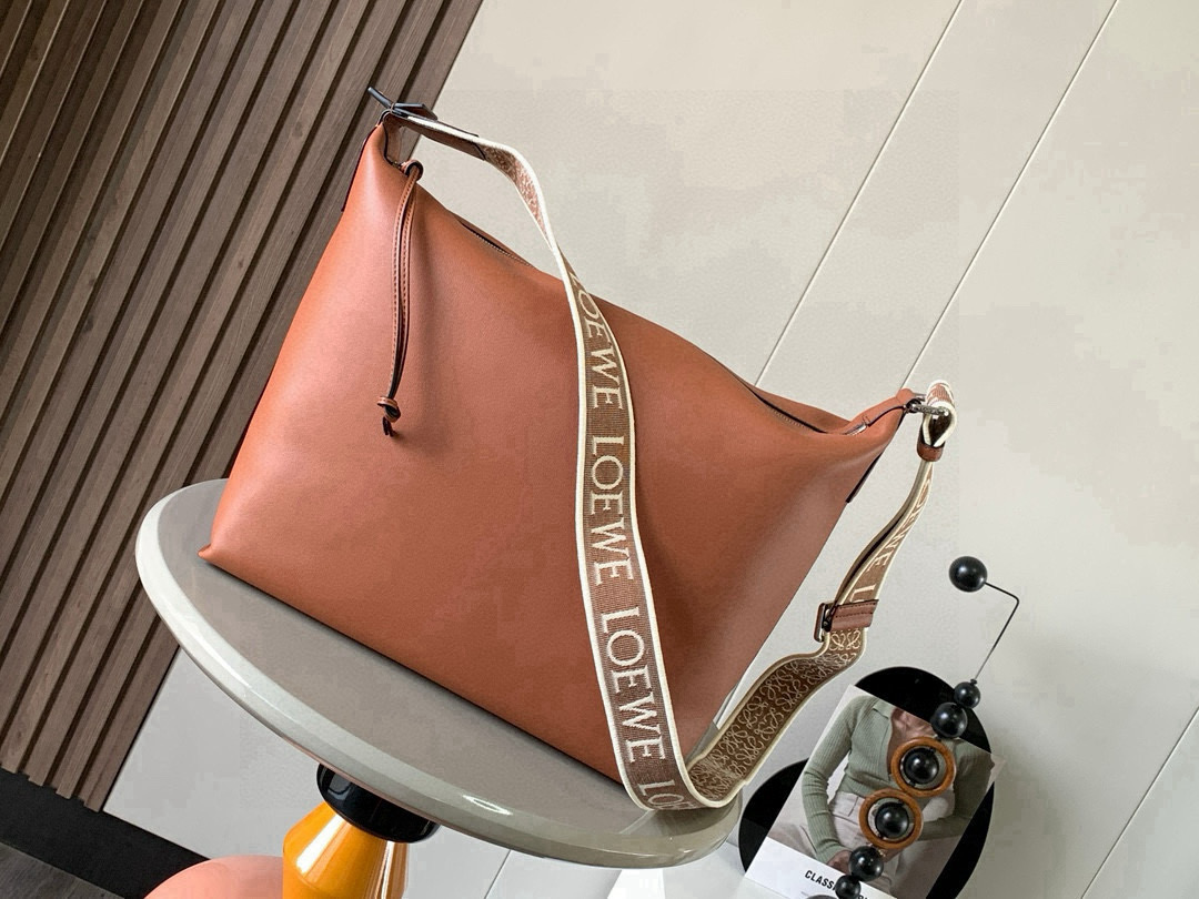 NO:719760,The Cubi crossbody bag makes a stunning appearance. This time, the Cubi is released. It is really surprising. It is equipped with a jacquard adjustable shoulder strap that feels soft on the skin, has a large capacity and is highly functional. It can be worn on one shoulder and under the armpit, and can be used as a gym bag. It is also a luggage bag for short trips. It is also very popular. The Cubi is really a good bag with very high overall quality.  The crossbody bag is a spacious and soft handbag that can easily adapt to the body shape. This version is made of soft and smooth cow leather, with a jacquard shoulder strap. It can be worn cross-body or on the shoulder. Adjustable shoulder strap. Zipper closure with cow leather zipper pull. Internal slip pocket. Can 19860909Cubi斜挎包惊艳亮相这次出了Cubi 真是让人惊喜配有提花可调节肩带手感亲肤柔和容量大功能性强 可以单肩腋下斜挎 可当健身包使用作为短途旅行的行李袋也是非常出圈、出片的真的是一只综合素质非常高的好包包Cubi 斜挎包是一款宽敞且柔软的手袋,可轻松适应体形此版本采用柔软光滑的牛皮革制成,搭配提花肩带.斜挎或肩背.可调节肩带.拉链开合带牛皮革拉链头.内部插袋.可放13寸笔记本电脑 尺寸44～30～18CM 款号9010 颜色棕色,罗意威,loewe,satchels,crossbody bags,cowhide,Bag