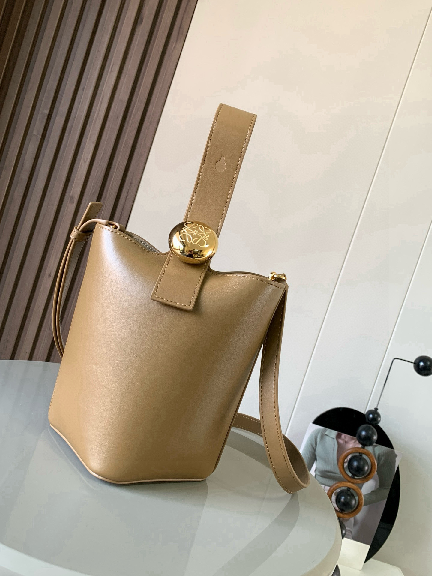 NO:719780,Mini soft grained calfskin Pebble Bucket Pebble cleverly combines pure simple lines with eye-catching design style to create a unique and innovative handbag design. Iconic Anagram  Engraved hardware is both decorative and functional, with an adjustable shoulder strap for multiple carry styles, with a unique twist complemented by subtle details. This mini version is crafted from soft grained calfskin. Can be worn cross-body, over the shoulder or by hand * Adjustable and removable shoulder strap * Magnetic closure * Internal pocket * Synthetic leather lining * Anagram Engraved Pebbles Style No. 9047 Color Oak Brown  Size 20CM～16CM～16CM, Loewe, loewe, cowhide19860909迷你柔软粒面牛皮革 Pebble Bucket 水桶手袋Pebble将纯粹的简约线条与瞩目设计风格巧妙融合造就别具一格的创新的手袋设计.标志性的 Anagram 雕刻五金件兼具装饰和实用功能,可调节肩带长度并适合多种携带方式,独特的扭曲结构与微妙的细节相得益彰.此迷你版本采用柔软粒面牛皮革制成.可斜挎、肩背或手提＊可调节可拆卸肩带＊磁扣开合＊内袋＊合成革衬里* Anagram 雕刻卵石 款号9047 颜色橡木棕 尺寸20CM～16CM～16CM,罗意威,loewe,cowhide,Bag