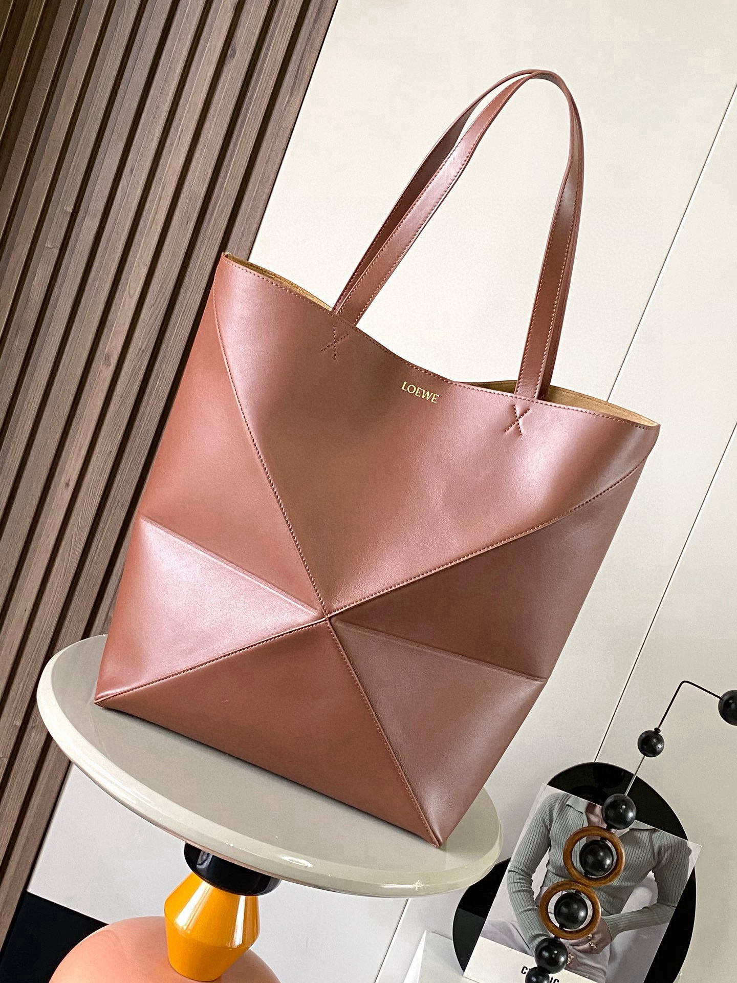 NO:719796,Large new shiny cow leather shopping bag puzzle Fold handbag large geometric pattern It has been a long time since I have seen such a practical and design tote bag. This continues the geometric aesthetics of the Puzzle series and is inspired by origami bags. This Puzzle Fold tote  I freely switch between three-dimensional and flat upper body sizes for your reference. The large size has a more friendly capacity, and the small size is very cute. The leather is very delicate and shiny. It is super light in weight. In addition, it can be folded, which is perfect for commuting with a computer, or for people like me who often travel on business and can easily store it in their luggage. Puzzle  The Fold handbag draws inspiration from the geometric lines of the brand's classic handbag series and uses creative ingenuity to reinterpret it into a fashionable tote bag that can be completely folded and is a good travel companion. This large version is made of soft glossy cowhide. Size 42CM～41CM～18CM. Style No. 9033. Color Browne, Loewe, Thom Browne, Loewe, Totes, Cowhide19860909大号新款亮面牛皮革购物袋puzzle Fold手袋大号几何图形玩出花了很久没见过这么实用又设计感满满的托特包了这款延续了Puzzle系列的几何美学以折纸包为灵感,让这只 Puzzle Fold tote 在立体和平面随意切换上身了两个尺码给大家参考哦大号容量更友好,小号很可爱,皮质都很细腻光泽本身自重超轻,外加可以折叠太适合平时带电脑通勤,或是像我一样经常出差旅行不费力的收纳进行李箱,Puzzle Fold手袋从品牌经典手袋系列的几何线条汲取灵感运用创意巧思将其重新诠释为一款时尚的托特袋,能完全折叠是旅行良伴.这个大号版本采用柔软的亮面牛皮革打造 尺寸42CM～41CM～18CM 款号9033 颜色布朗尼,罗意威,thom browne,loewe,totes,cowhide,Bag