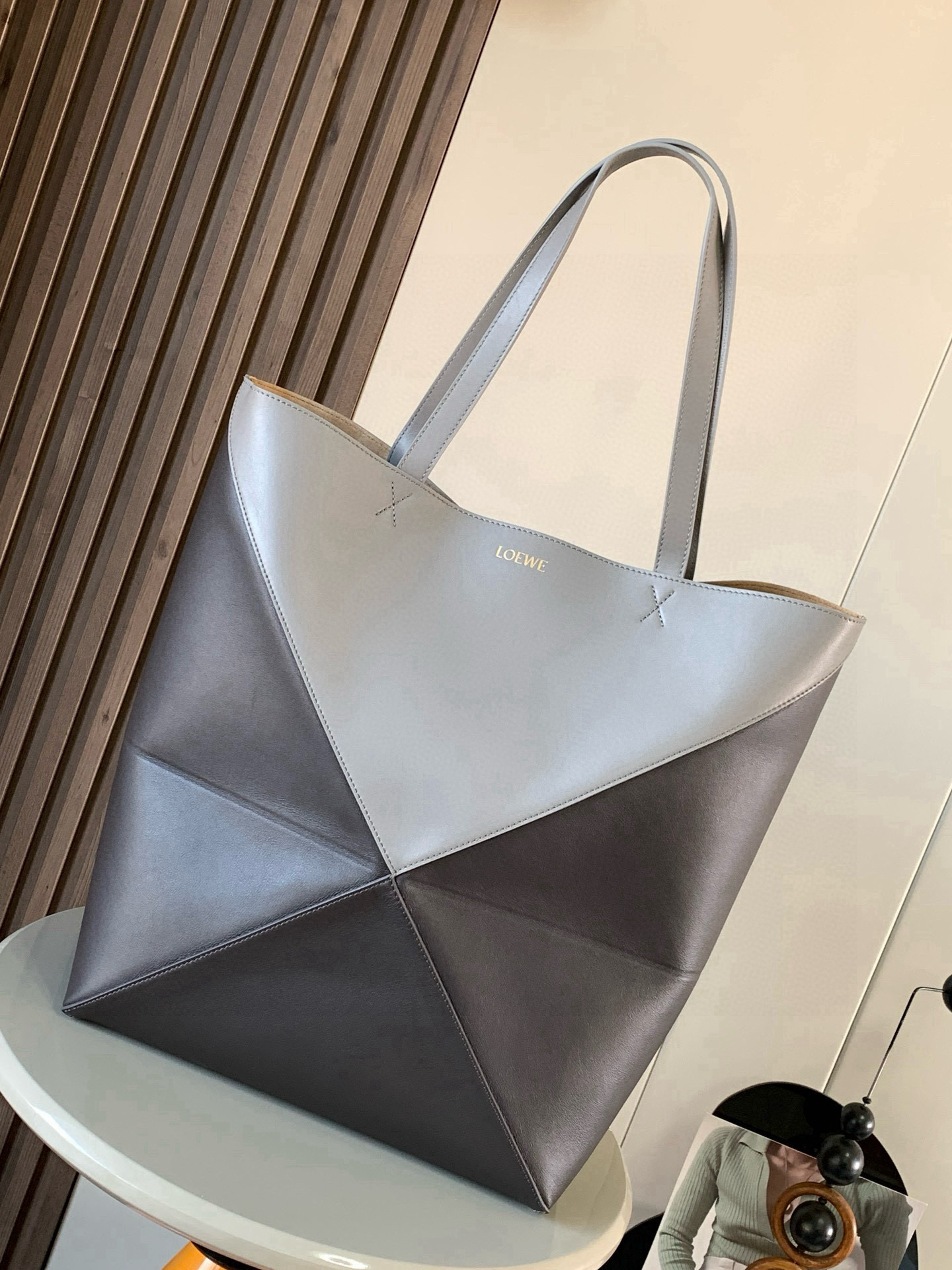 NO:719805,Large new shiny cow leather shopping bag puzzle Fold handbag large geometric pattern It has been a long time since I have seen such a practical and design tote bag. This continues the geometric aesthetics of the Puzzle series and is inspired by origami bags. This Puzzle Fold tote  I freely switch between three-dimensional and flat upper body sizes for your reference. The large size has a more friendly capacity, and the small size is very cute. The leather is very delicate and shiny. It is super light in weight. In addition, it can be folded, which is perfect for commuting with a computer, or for people like me who often travel on business and can easily store it in their luggage. Puzzle  The Fold handbag draws inspiration from the geometric lines of the brand's classic handbag series and uses creative ingenuity to reinterpret it into a fashionable tote bag that can be fully folded and is a good travel companion. This large version is made of soft glossy cowhide. Size 42CM ~ 41CM ~ 18CM. Style No. 9033. Color: Asphalt, Loewe, totes, cowhide19860909大号新款亮面牛皮革购物袋puzzle Fold手袋大号几何图形玩出花了很久没见过这么实用又设计感满满的托特包了这款延续了Puzzle系列的几何美学以折纸包为灵感,让这只 Puzzle Fold tote 在立体和平面随意切换上身了两个尺码给大家参考哦大号容量更友好,小号很可爱,皮质都很细腻光泽本身自重超轻,外加可以折叠太适合平时带电脑通勤,或是像我一样经常出差旅行不费力的收纳进行李箱,Puzzle Fold手袋从品牌经典手袋系列的几何线条汲取灵感运用创意巧思将其重新诠释为一款时尚的托特袋,能完全折叠是旅行良伴.这个大号版本采用柔软的亮面牛皮革打造 尺寸42CM～41CM～18CM 款号9033 颜色沥青太咖灰,罗意威,loewe,totes,cowhide,Bag