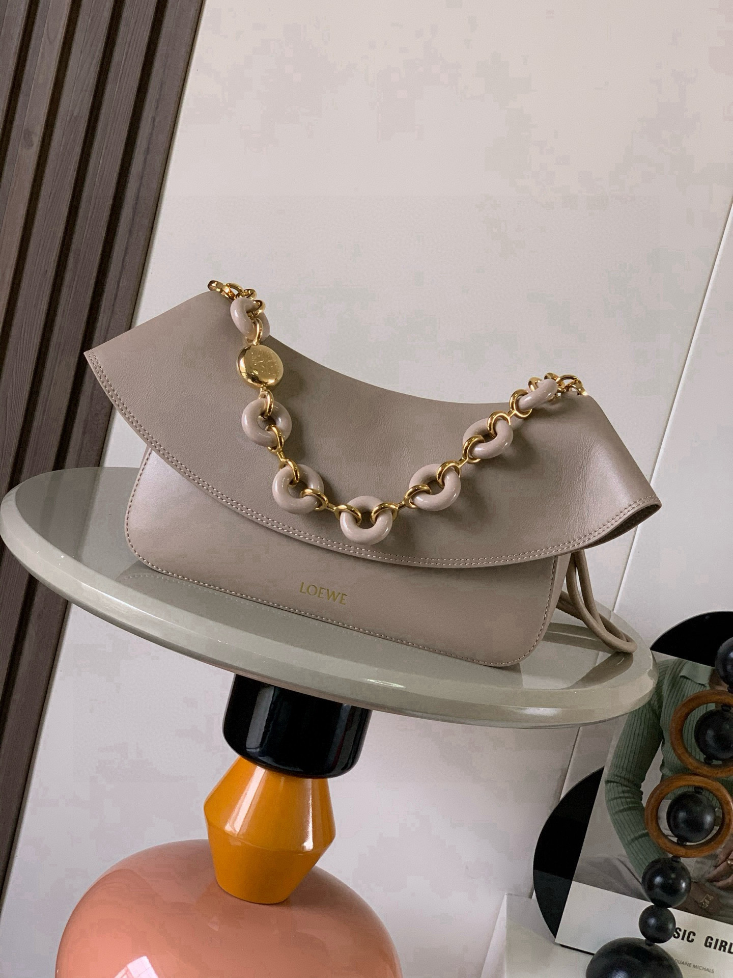 NO:720046,Medium Smooth Cow Leather Ola Handbag Ola is a soft, lightweight, flexible and versatile summer handbag with a curved body, a smooth-line flap and a striking donut chain. This medium version is made of smooth cow leather * Detachable cow leather tubular shoulder strap Detachable donut chain * Flap closure * One inner pocket L0EWE Hot stamping, engraved Anagram logo Size 26CM ~ 18CM ~ 13CM Style No. 9150  Color sandy,loewe,loewe,cowhide19860909中号光滑牛皮革 Ola 手袋Ola 是柔软轻便且灵活百搭的夏日手袋采用弧形主体、线条流畅的翻盖和醒目甜甜圈链条此中号版本采用光滑牛皮革制成*可拆卸牛皮革管状肩带可拆卸甜甜圈链条*翻盖开合*一个内袋 L0EWE 烫金,镌刻 Anagram 标志 尺寸26CM～18CM～13CM 款号9150 颜色沙色,罗意威,loewe,cowhide,Bag