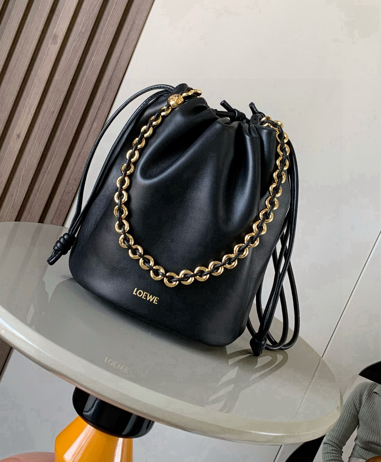 NO:741321,New soft nappa sheep leather Flamenco Purse Bucket bucket handbag The new Flamenco Purse handbag adopts pleated design and key details such as iconic knots on the side Bucket  The Bucket bag is available in new sizes for everyday use while retaining the collection's feminine style. The style is stylish and versatile and can be worn over the shoulder with a donut chain or worn cross-body with a leather strap. This version is made from soft nappa leather.  Hot stamping or hot silver, size 32cm～17cm～24cm, style number 9062, color black, Loewe, loewe, sheepskin19860909新款柔软纳帕羊皮革 Flamenco Purse Bucket 水桶手袋新品Flamenco Purse 手袋采用褶皱设计侧面搭配标志性绳结等关键细节Bucket 水桶手袋推出适合日常使用的全新尺寸同时保留此系列的柔美风格.款式时尚百搭,可搭配甜甜圈链条肩背或搭配皮革肩带斜挎此版本采用柔软纳帕羊皮革制成.＊可肩背、斜挎或手提＊可拆卸可调节皮革肩带＊可拆卸甜甜圈链条饰有 Anagram 镌刻卵石纹＊低调的磁扣开合＊绒面革衬里＊ L O EWE 烫金或烫银 尺寸32cm～17cm～24cm 款号9062 颜色黑色,罗意威,loewe,sheepskin,Bag