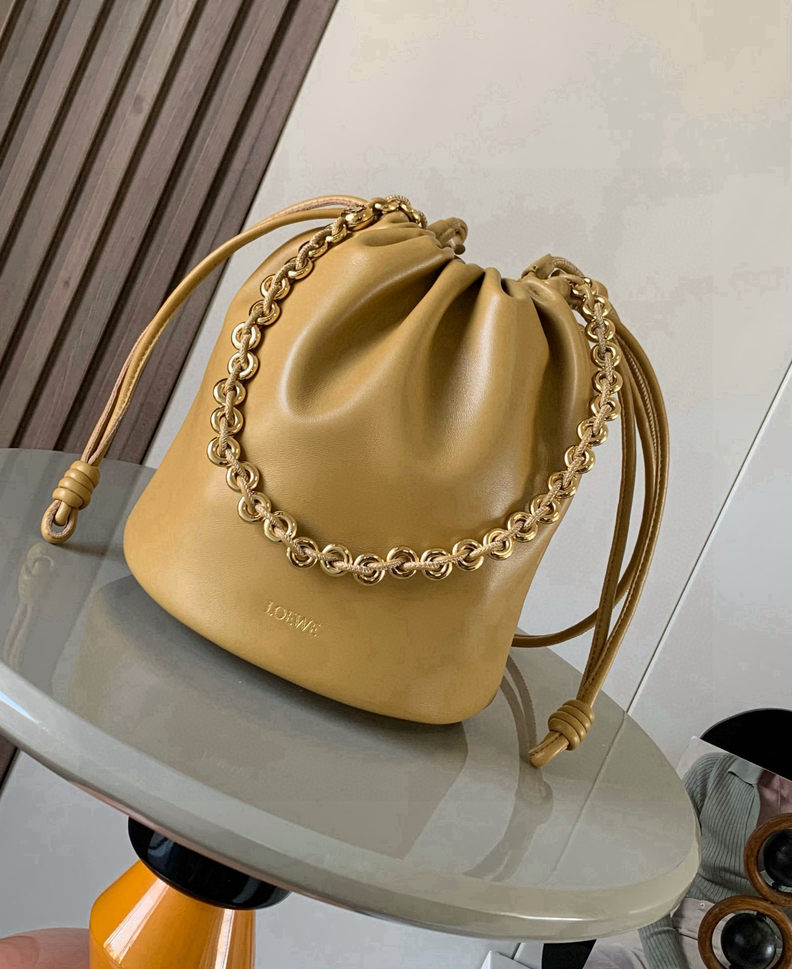 NO:741324,New soft nappa sheep leather Flamenco Purse Bucket bucket handbag The new Flamenco Purse handbag adopts pleated design and key details such as iconic knots on the side Bucket  The Bucket bag is available in new sizes for everyday use while retaining the collection's feminine style. The style is stylish and versatile and can be worn over the shoulder with a donut chain or worn cross-body with a leather strap. This version is made from soft nappa leather.  Hot stamping or silver, size 32cm～17cm～24cm, style number 9062, color desert yellow, Loewe, loewe, sheepskin19860909新款柔软纳帕羊皮革 Flamenco Purse Bucket 水桶手袋新品Flamenco Purse 手袋采用褶皱设计侧面搭配标志性绳结等关键细节Bucket 水桶手袋推出适合日常使用的全新尺寸同时保留此系列的柔美风格.款式时尚百搭,可搭配甜甜圈链条肩背或搭配皮革肩带斜挎此版本采用柔软纳帕羊皮革制成.＊可肩背、斜挎或手提＊可拆卸可调节皮革肩带＊可拆卸甜甜圈链条饰有 Anagram 镌刻卵石纹＊低调的磁扣开合＊绒面革衬里＊ L O EWE 烫金或烫银 尺寸32cm～17cm～24cm 款号9062 颜色沙漠黄,罗意威,loewe,sheepskin,Bag