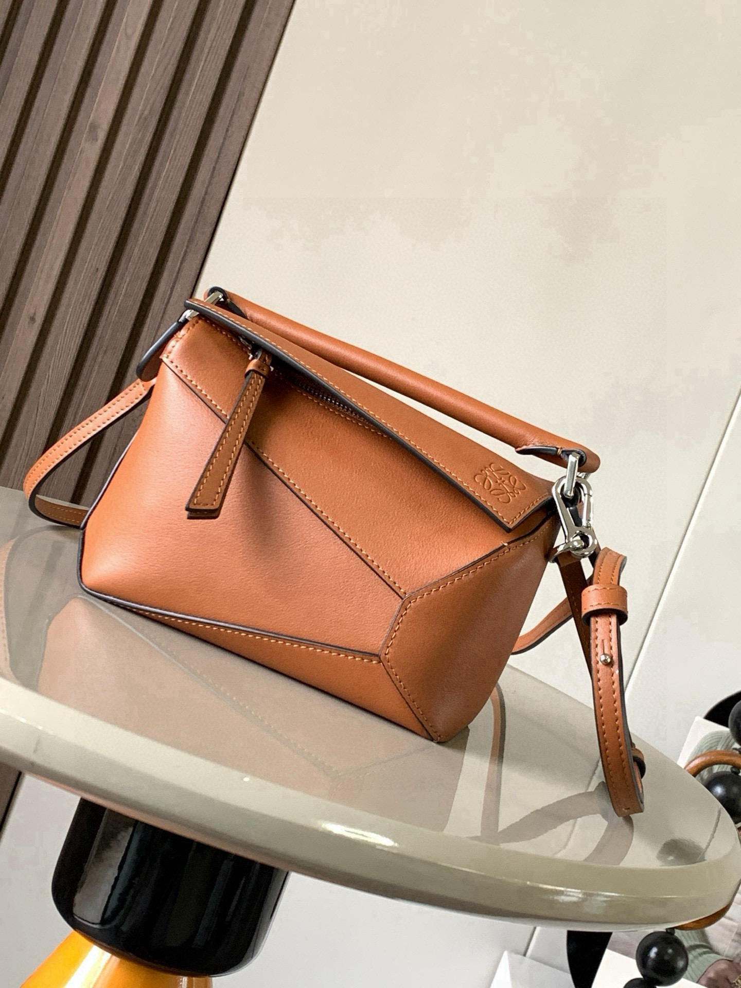 NO:741480,The popular new version of the geometric bag mini 18CM imported Napa calfskin Puzzle handbag is the creative director of Jonathan.  Anderson's first handbag for L0EWE The cuboid shape and precise cutting techniques create the unique geometric lines of the Puzzle. This mini version is crafted from classic cowhide leather The Mini Puzzle  It can accommodate, for example, a small vertical wallet, mobile phones of most sizes (up to 6.1 inches) and sunglasses cases to be carried across the body, on the shoulder, in the hand or by the top handle. The detachable shoulder strap almost ignores the weight of the bag itself, making it practical for carrying mobile phones, small purses, lipsticks and powders when going out, without any sense of cumbersomeness, and a relaxed and happy life starts from now on (the xs and plus you are most concerned about are all OK). Size 18～12.5～8CM, style number 9310～8003  Color brown,loewe,loewe,wallets,cowhide19860909爆款新版本几何包迷你18CM原厂进口纳帕小牛皮Puzzle手袋是创意总监乔纳森．安德森为 L0EWE 推出的首款手提包长方体形状和精确的切割技术创造了 Puzzle 独特的几何线条.这个迷你版本采用经典牛皮革制成迷你 Puzzle 可以容纳例如一只小号垂直钱包、大多数尺寸的手机（最大6.1英寸）和太阳镜盒斜挎、肩背、手拿或顶部提手携带.可拆卸肩带包包自身重量几乎忽略,炒鸡实用,出门装手机小钱包口红粉饼,毫无累赘感,轻松愉快人生从此开启(你们最关心的xs,plus都ok哈） 尺寸18～12.5～8CM 款号9310～8003 颜色棕色,罗意威,loewe,wallets,cowhide,Bag