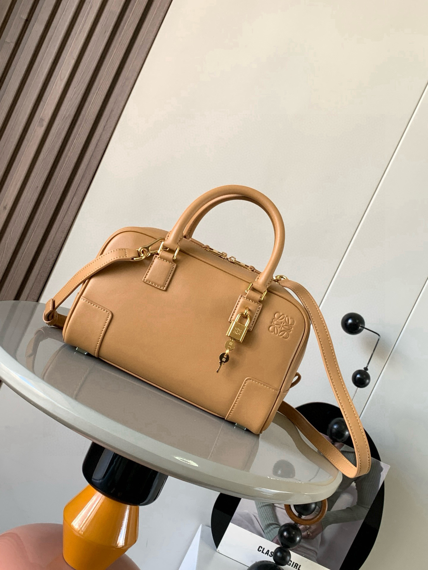NO:770514,Amazona 23 Bag in Nappa Cow Leather The Amazona is LOEWE's iconic bag, originally launched in the 1970s as a top-handle soft-structure bag. This Nappa cow leather version is updated with refined proportions and details, including an Anagram  Engraved padlock * Cross-body, shoulder or top handle carry * Detachable and adjustable shoulder strap * Dual zipper closure * Cow leather zipper pull * Internal zip compartment and snap-fastened slip pocket * Mini pocket for padlock keys * Protective metal feet at base * Can be customized with shoulder strap and personalized charms * Gold suede lining * Anagram embossed  Size 23cm～10cm～15cm Style number 9078 Color brown pattern, Loewe, loewe, loewe, cowhide19860909纳帕牛皮革 Amazona 23 手袋Amazona 是 LOEWE 的标志性手袋,最初于1970年代作为顶部提手软结构手袋推出这款纳帕牛皮革版本更新了精致的比例和细节,包括一个 Anagram 雕刻挂锁＊斜挎、肩背或顶部提手携带＊可拆卸可调节肩带＊双拉链开合＊牛皮革拉链头＊内部拉链隔层和按扣固定的插袋＊用于存放挂锁钥匙的迷你口袋＊底部保护性金属脚＊可以使用肩带和个性化挂饰进行定制＊金色绒面革衬里＊ Anagram 压纹 尺寸23cm～10cm～15cm 款号9078 颜色棕色纹,罗意威,loewe,loewe,cowhide,Bag