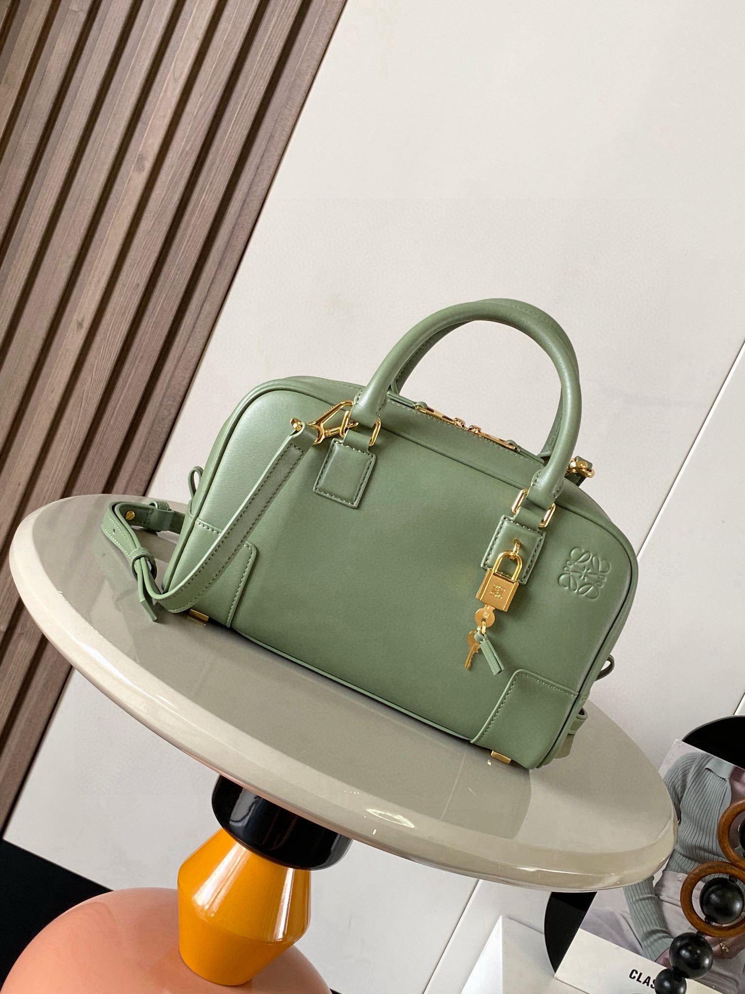 NO:770522,Amazona 23 Bag in Nappa Cow Leather The Amazona is LOEWE's iconic bag, originally launched in the 1970s as a top-handle soft-structure bag. This Nappa cow leather version is updated with refined proportions and details, including an Anagram  Engraved padlock * Cross-body, shoulder or top handle carry * Detachable and adjustable shoulder strap * Dual zipper closure * Cow leather zipper pull * Internal zip compartment and snap-fastened slip pocket * Mini pocket for padlock keys * Protective metal feet at base * Can be customized with shoulder strap and personalized charms * Gold suede lining * Anagram embossed  Size 23cm～10cm～15cm Style number 9078 Color green pattern, Loewe, loewe, loewe, cowhide19860909纳帕牛皮革 Amazona 23 手袋Amazona 是 LOEWE 的标志性手袋,最初于1970年代作为顶部提手软结构手袋推出这款纳帕牛皮革版本更新了精致的比例和细节,包括一个 Anagram 雕刻挂锁＊斜挎、肩背或顶部提手携带＊可拆卸可调节肩带＊双拉链开合＊牛皮革拉链头＊内部拉链隔层和按扣固定的插袋＊用于存放挂锁钥匙的迷你口袋＊底部保护性金属脚＊可以使用肩带和个性化挂饰进行定制＊金色绒面革衬里＊ Anagram 压纹 尺寸23cm～10cm～15cm 款号9078 颜色绿色纹,罗意威,loewe,loewe,cowhide,Bag
