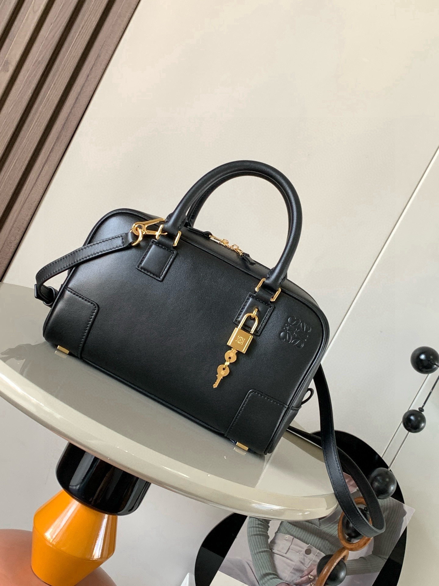 NO:770483,Amazona 23 Bag in Nappa Cow Leather The Amazona is LOEWE's iconic bag, originally launched in the 1970s as a top-handle soft-structure bag. This Nappa cow leather version is updated with refined proportions and details, including an Anagram  Engraved padlock * Cross-body, shoulder or top handle carry * Detachable and adjustable shoulder strap * Dual zipper closure * Cow leather zipper pull * Internal zip compartment and snap-fastened slip pocket * Mini pocket for padlock keys * Protective metal feet at base * Can be customized with shoulder strap and personalized charms * Gold suede lining * Anagram embossed  Size 23cm～10cm～15cm Style number 9078 Color black, Loewe, loewe, loewe, cowhide19860909纳帕牛皮革 Amazona 23 手袋Amazona 是 LOEWE 的标志性手袋,最初于1970年代作为顶部提手软结构手袋推出这款纳帕牛皮革版本更新了精致的比例和细节,包括一个 Anagram 雕刻挂锁＊斜挎、肩背或顶部提手携带＊可拆卸可调节肩带＊双拉链开合＊牛皮革拉链头＊内部拉链隔层和按扣固定的插袋＊用于存放挂锁钥匙的迷你口袋＊底部保护性金属脚＊可以使用肩带和个性化挂饰进行定制＊金色绒面革衬里＊ Anagram 压纹 尺寸23cm～10cm～15cm 款号9078 颜色黑色,罗意威,loewe,loewe,cowhide,Bag