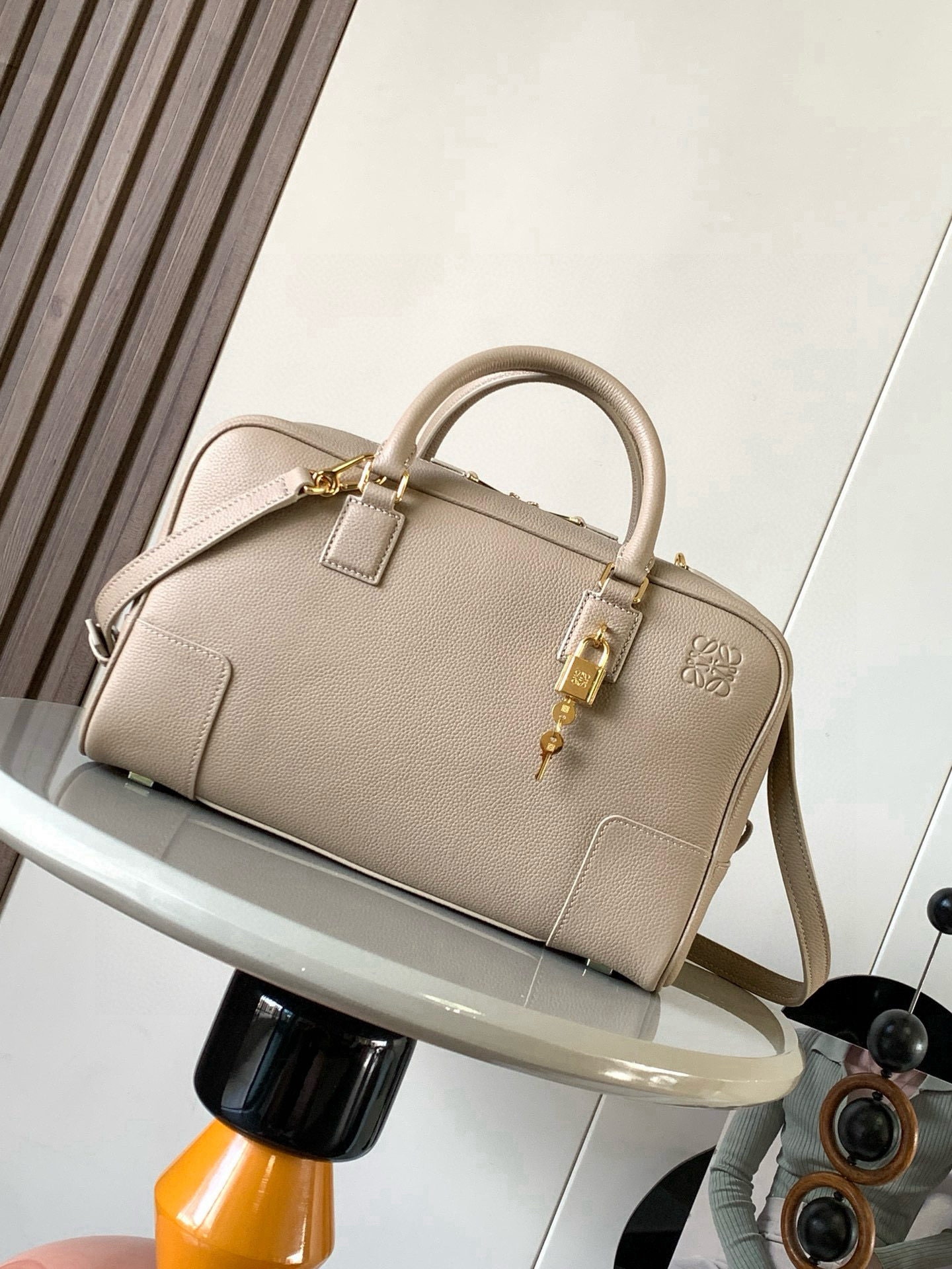NO:770502,Amazona 28 Handbag in Nappa Cow Leather The Amazona is LOEWE's iconic bag, originally launched in the 1970s as a top-handle soft-structure handbag. This Nappa cow leather version has been updated with refined proportions and details, including an Anagram  Engraved padlock * Cross-body, shoulder or top handle carry * Detachable and adjustable shoulder strap * Dual zipper closure * Cow leather zipper pull * Internal zip compartment and snap-fastened slip pocket * Mini pocket for padlock keys * Protective metal feet at base * Can be customized with shoulder strap and personalized charms * Gold suede lining * Anagram embossed  Size 28cm～11cm～18cm Style No. 9080 Color sandy liche, Loewe, loewe, loewe, cowhide19860909纳帕牛皮革 Amazona 28手袋Amazona 是 LOEWE 的标志性手袋,最初于1970年代作为顶部提手软结构手袋推出这款纳帕牛皮革版本更新了精致的比例和细节,包括一个 Anagram 雕刻挂锁＊斜挎、肩背或顶部提手携带＊可拆卸可调节肩带＊双拉链开合＊牛皮革拉链头＊内部拉链隔层和按扣固定的插袋＊用于存放挂锁钥匙的迷你口袋＊底部保护性金属脚＊可以使用肩带和个性化挂饰进行定制＊金色绒面革衬里＊Anagram 压纹 尺寸28cm～11cm～18cm 款号9080 颜色沙色荔,罗意威,loewe,loewe,cowhide,Bag