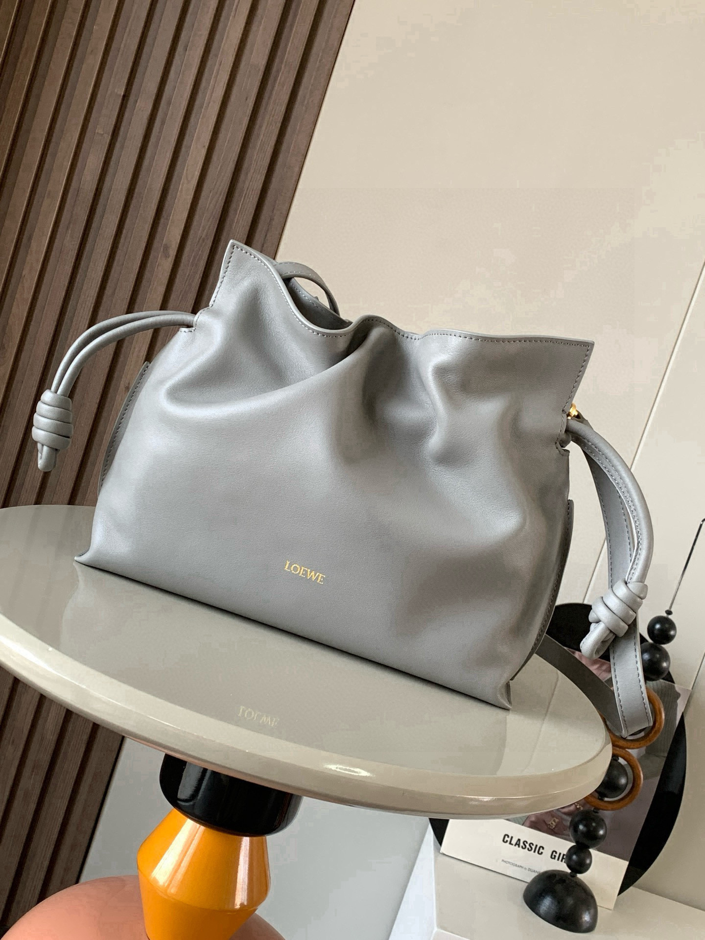 NO:770578,The new version of Dream Lucky Bag is 30CM. The new Napa cow leather Flamenco clutch bag is tightened with a drawstring and tied with the iconic coiled knot. This version is made of Napa cow leather. It must be said that this brand fully demonstrates the softness and pragmatism of the leather in Flamenco Knot. It can be said that you can feel whatever you want at Flamenco.  I found the perfect combination of drawstring bag and tote bag in Knot, which gives girls a different feeling. Although it looks simple, it is also very special and casual. The name of this bag is the same as the flamenco dance of the Spanish gypsies, which also represents Loewe's casual, elegant and personalized design style. The leather is smooth Spanish calfskin, which feels particularly soft. The anti-suede leather lining is very solid and scratch-resistant. It has been highly exposed in street photos. In addition to being used as a shoulder  The bag can also be used as a handbag with the characteristic drawstring design and soft leather loading. Tightening the rope makes the lines smoother. It is very suitable for work or leisure. Size 30CM~24.5CM~10.5CM. Style number 9043. New color. Asphalt gray gold buckle, Loewe, loewe, totes, handbag, cowhide19860909新版梦福袋30CM新款纳帕牛皮革Flamenco手拿包福袋采用拉绳收紧,并打上标志性的盘绕结这个版本采用纳帕牛皮革制成不得不说,这个品牌将皮质的柔软和实用主义都在Flamenco Knot上展现得淋漓尽致可以说是想要什么感觉都能在Flamenco Knot中找到了将抽绳包和托特包完美结合,带给女生们不一样的感觉虽然看上去简单不能再简单,但又很特别,随性有范这款包的名字与西班牙吉卜赛人的弗朗明戈舞蹈同名这恰好也代表着罗意威随性优雅又个性洒脱的设计风格皮料是光滑的西班牙小牛皮,手感特别软,反绒面皮革里衬很扎实耐刮,街拍中曝光率极高的它,除了可作shoulder bag亦可作手提袋特色的拉绳设计,以及柔软皮革加载,拉紧绳索更显流畅线条,无论上班或休闲都非常得宜 尺寸30CM~24.5CM~10.5CM 款号9043 新款 颜色沥青灰金扣,罗意威,loewe,totes,handbag,cowhide,Bag